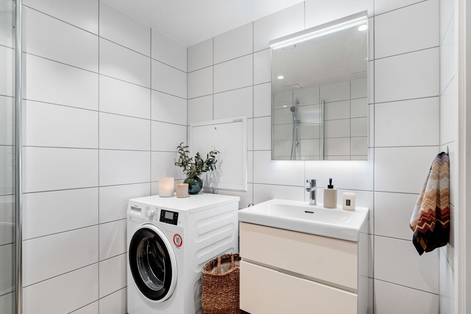 Badet er innredet med underskap, servant, speil, klosett og dusjhjørne. Det er opplegg for vaskemaskin. Galleribilde