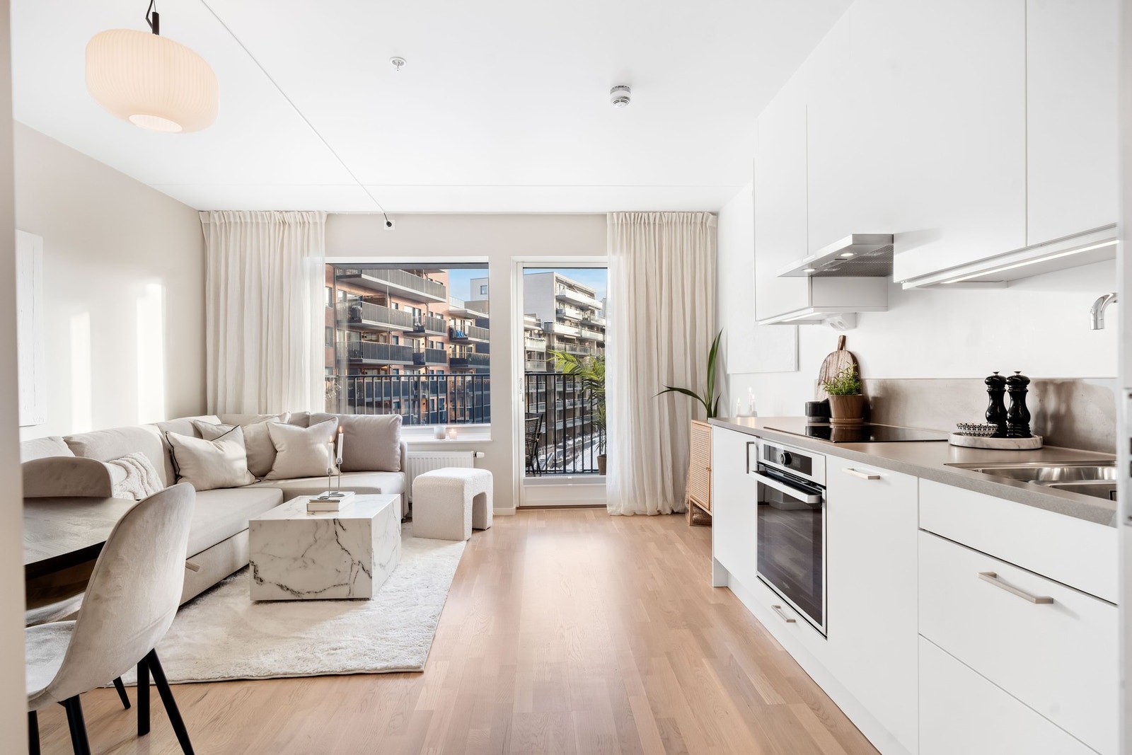 Lys og trivelig stue med store vindu og nøytrale overflater. Gulvet er belagt med parkett. Galleribilde