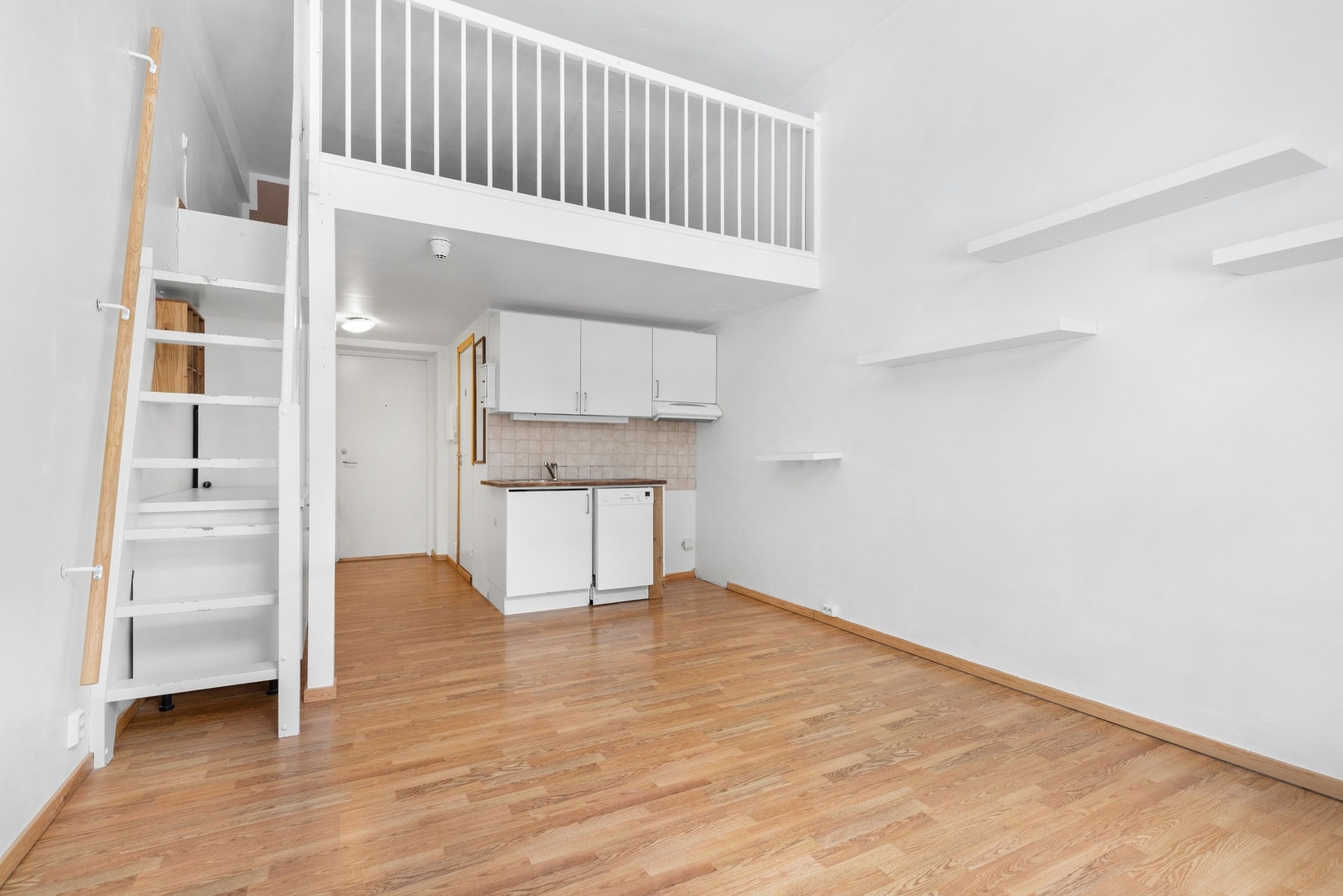 Stuen og kjøkkenet utgjør et åpent og sosialt allrom, med imponerende takhøyde og mye naturlig lys via en stor vindusflate i front. Galleribilde