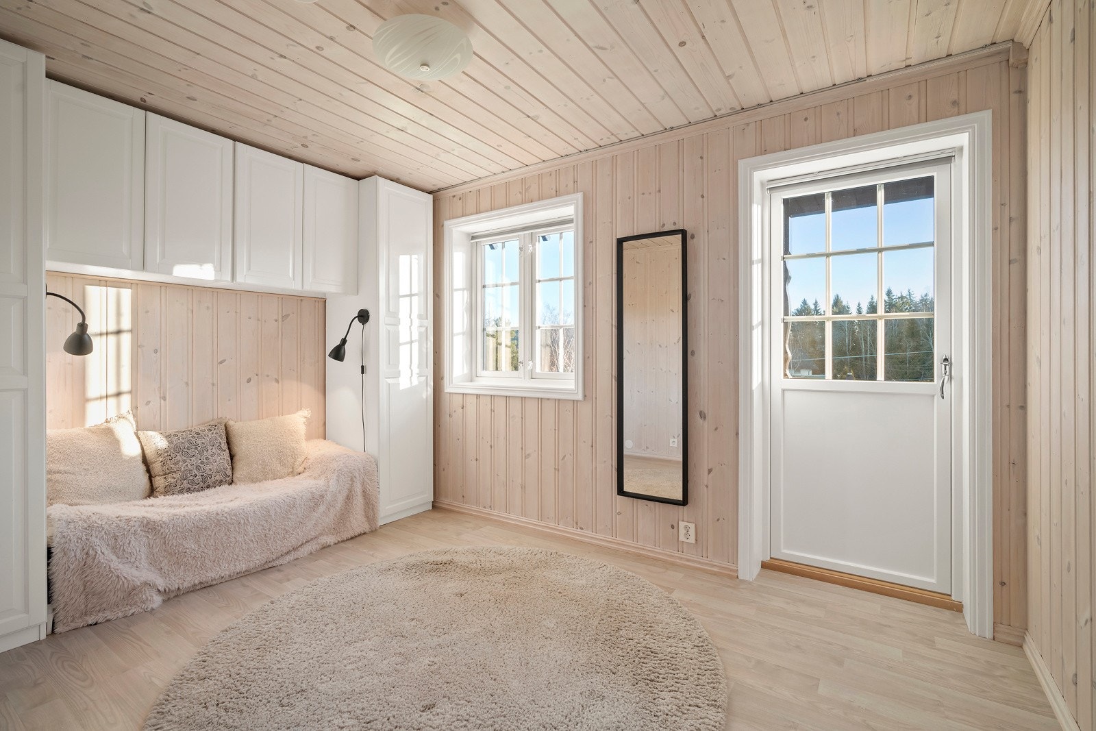 Soverommet i første etasje har parkett på gulvet og lyst panel på veggene. Galleribilde