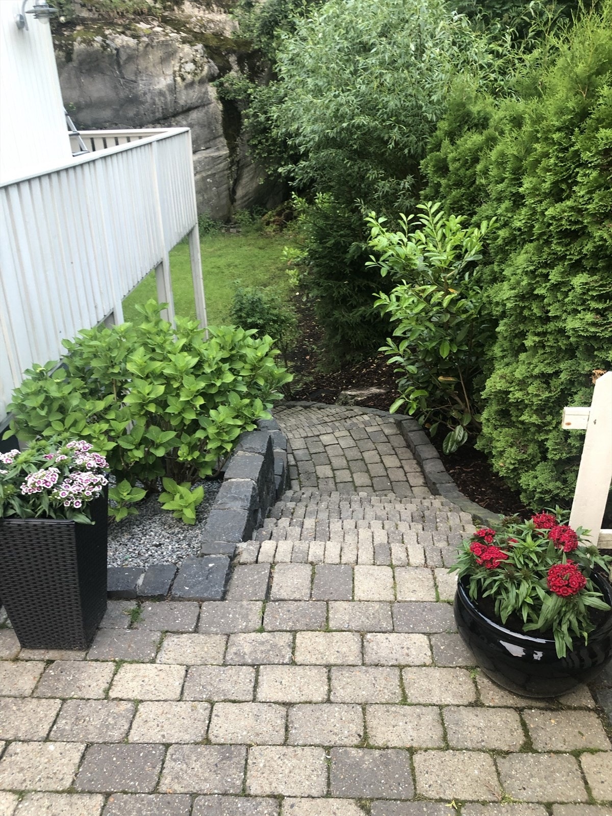 Eiendommen er pent opparbeidet, her trapp fra uteplass ned til usjenert stor hage med god plass til lek og morro. Galleribilde