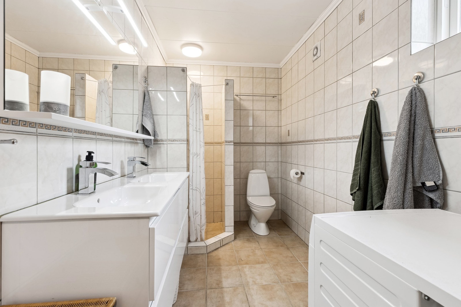 Utleiedel: Romslig, flislagt bad med dusjhjørne, dobbel servant, gulvstående toalett og plass til vaskemaskin. Galleribilde