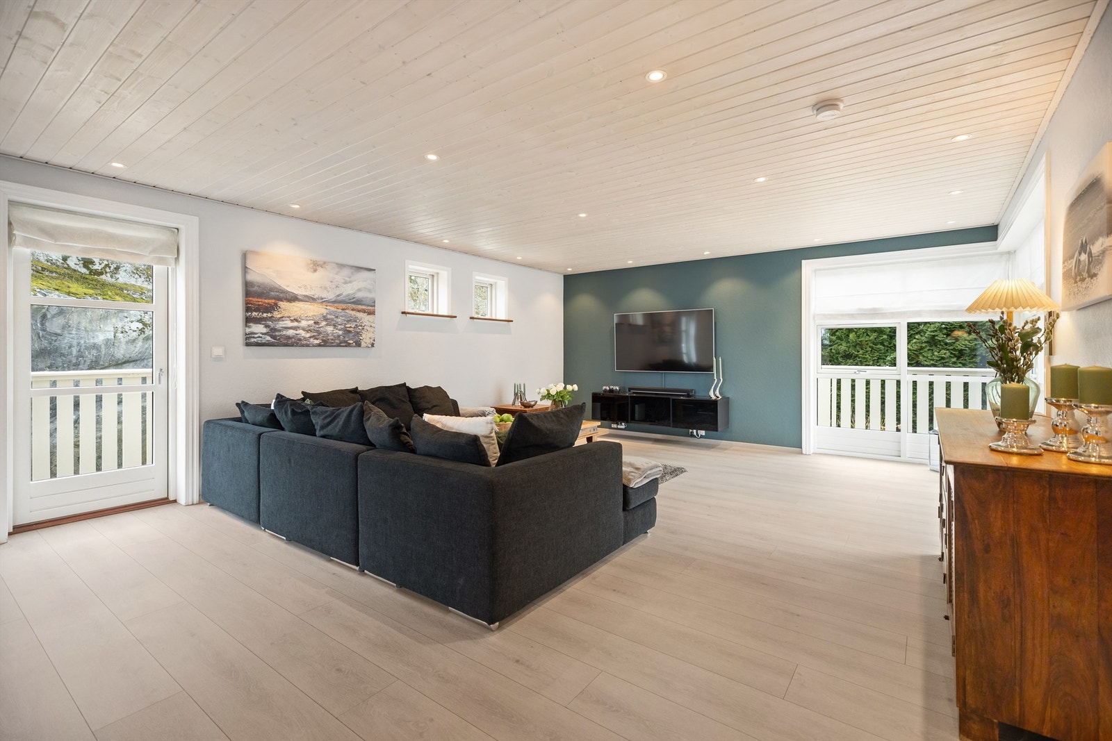 Store vinduer fyller rommet med naturlig lys og skaper en god atmosfære. Galleribilde