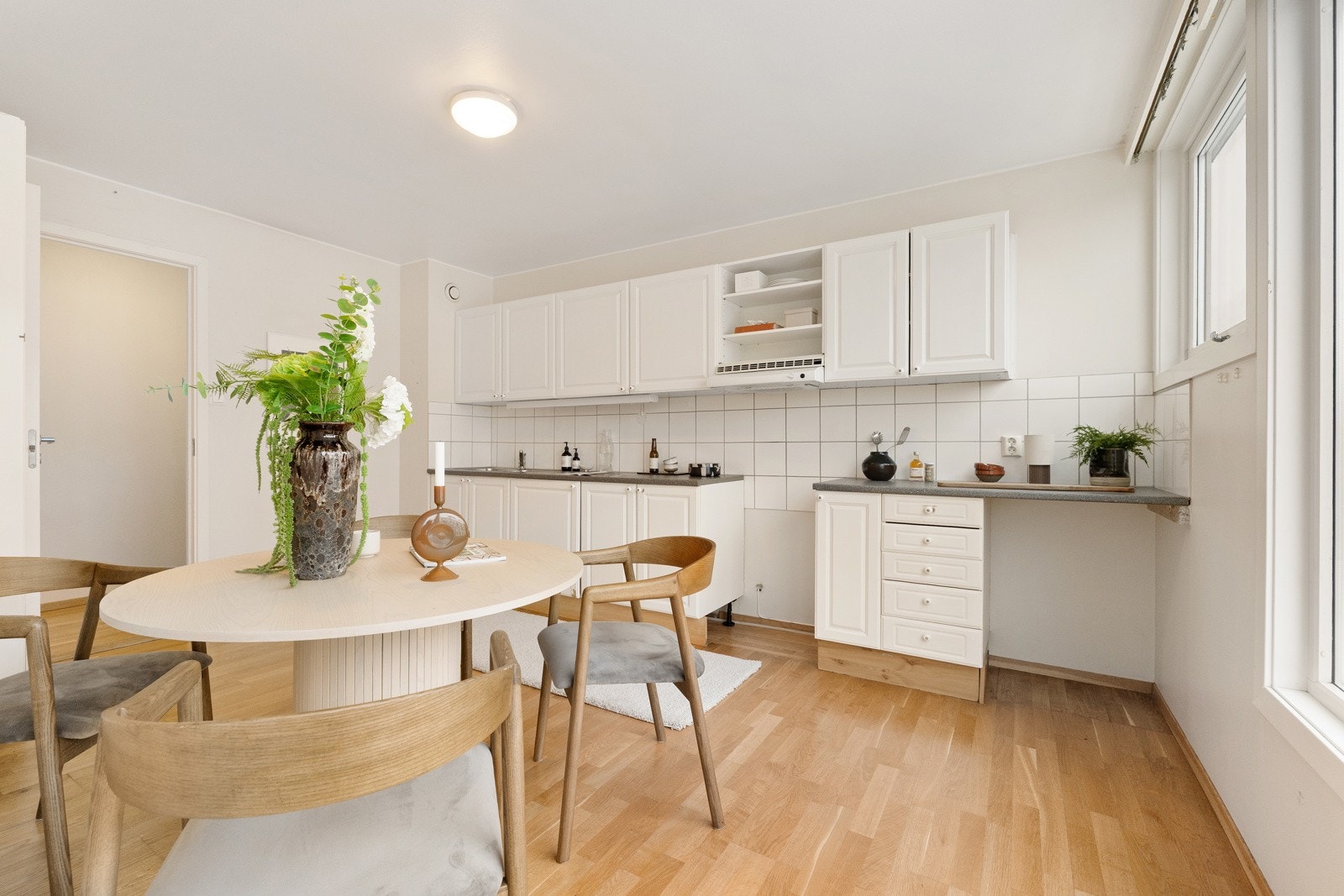 Eldre kjøkkeninnredning med profilerte fronter, laminert benkeplate som har overliggende oppvaskkum med ett greps blandebatteri fra Oras. Galleribilde