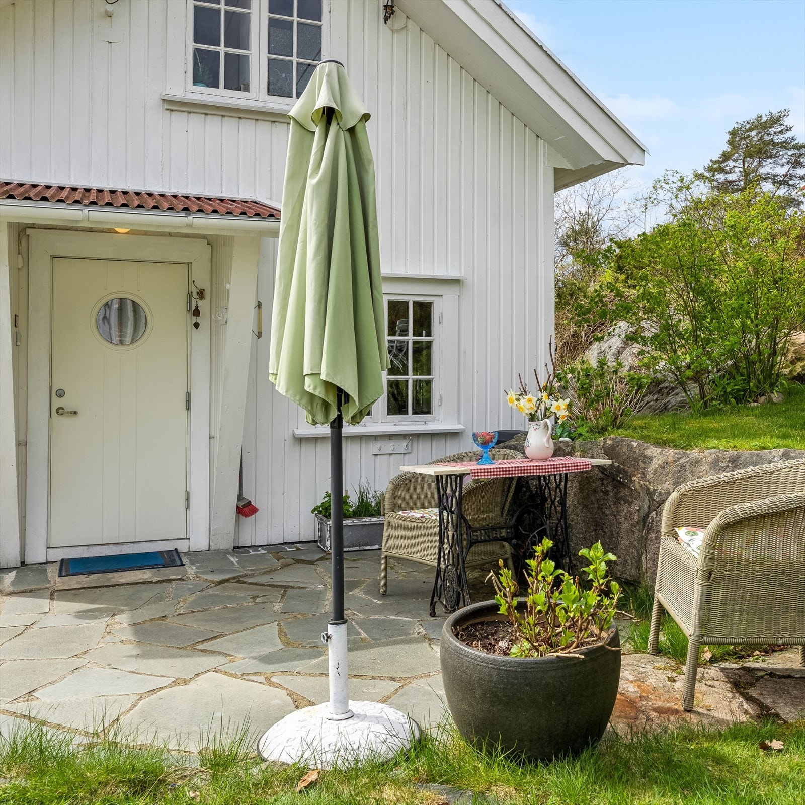 Pent opparbeidet uteområde ved inngangen, med steinplatting som skaper en hyggelig velkomst. Galleribilde