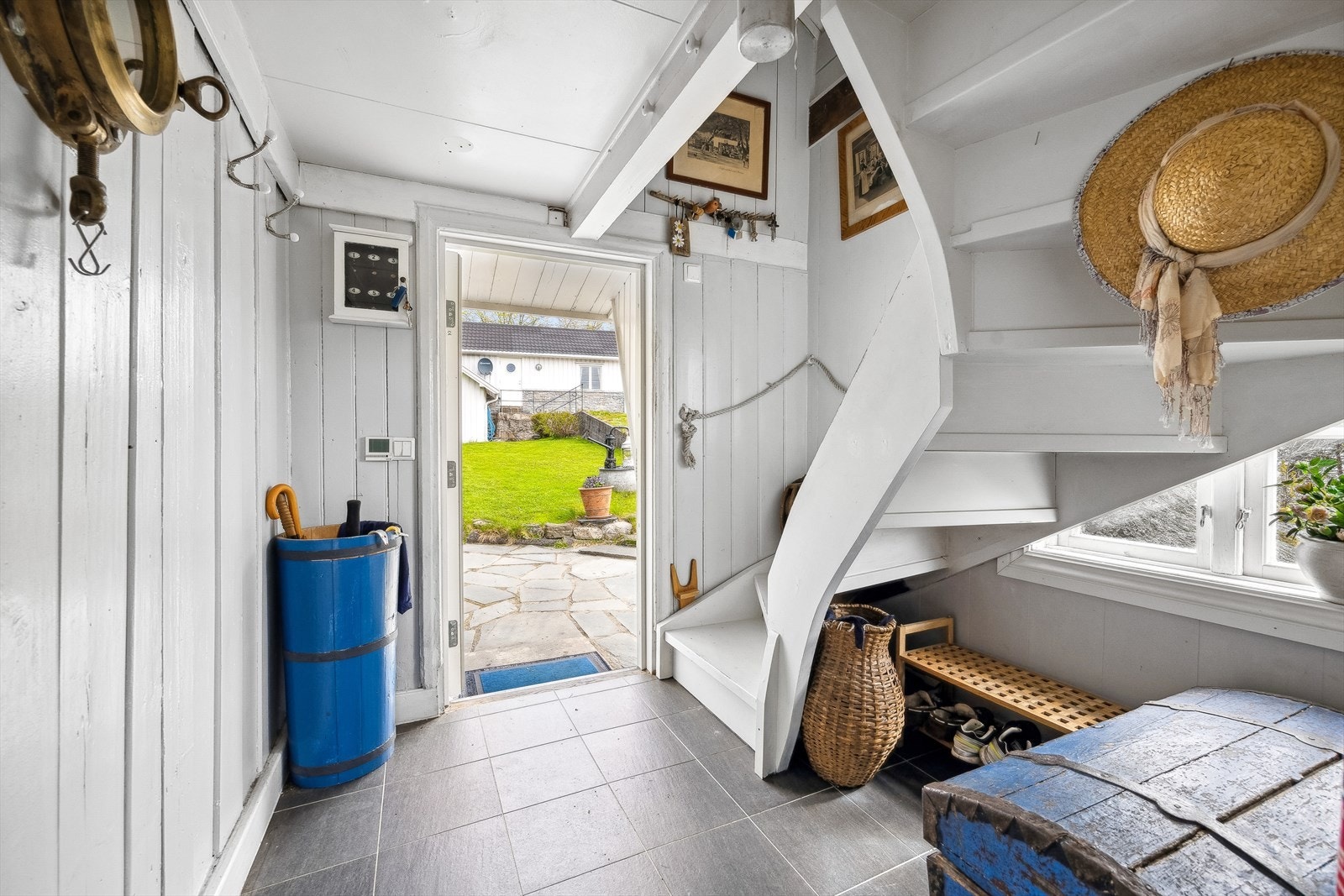 Innbydende entré med flislagt gulv og malt panel på veggene - en smakfull introduksjon til boligens sjarm og karakter. Galleribilde