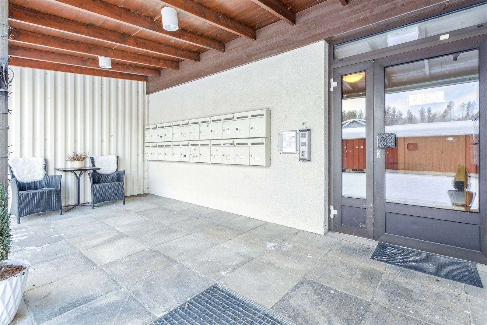 Overbygd og flislagt inngangsparti som leder inn til fellesarealene. Galleribilde