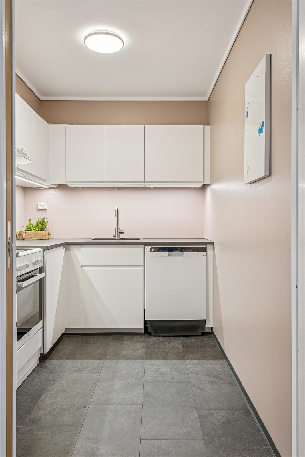 Kjøkkeninnredningen har en smart L-form som utnytter plassen godt. Galleribilde