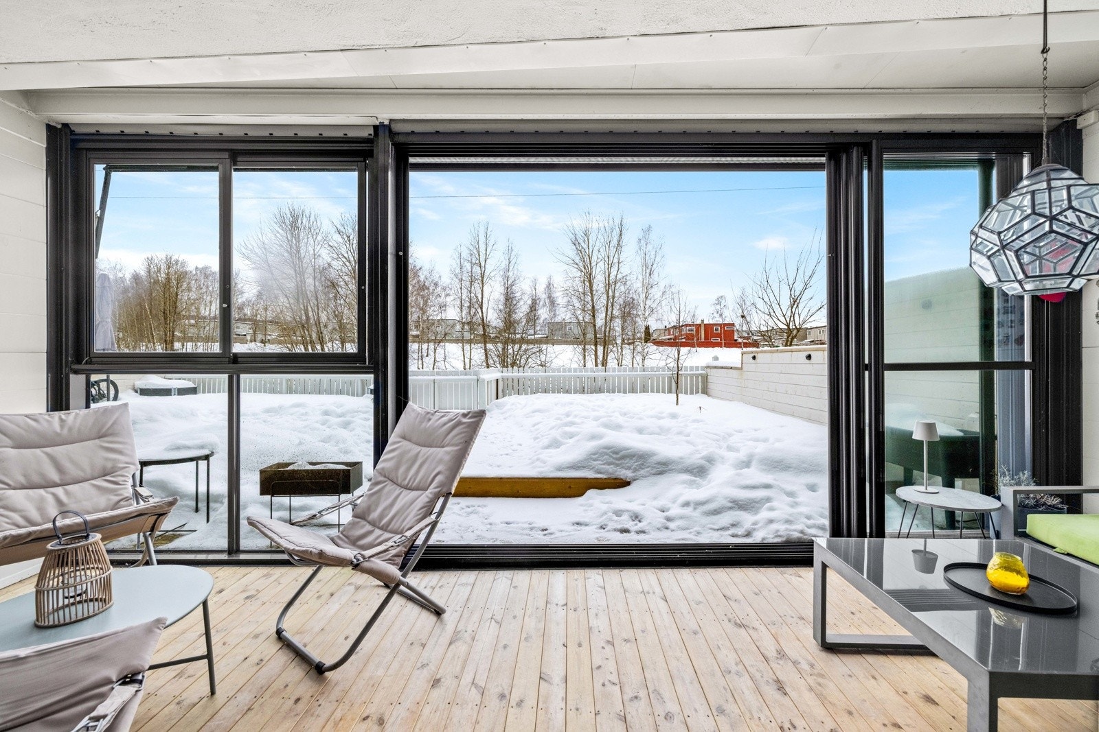 Ingen innsyn inn til allrommet. Bred skyvedør i glass ut til de fine uteområdene. Galleribilde