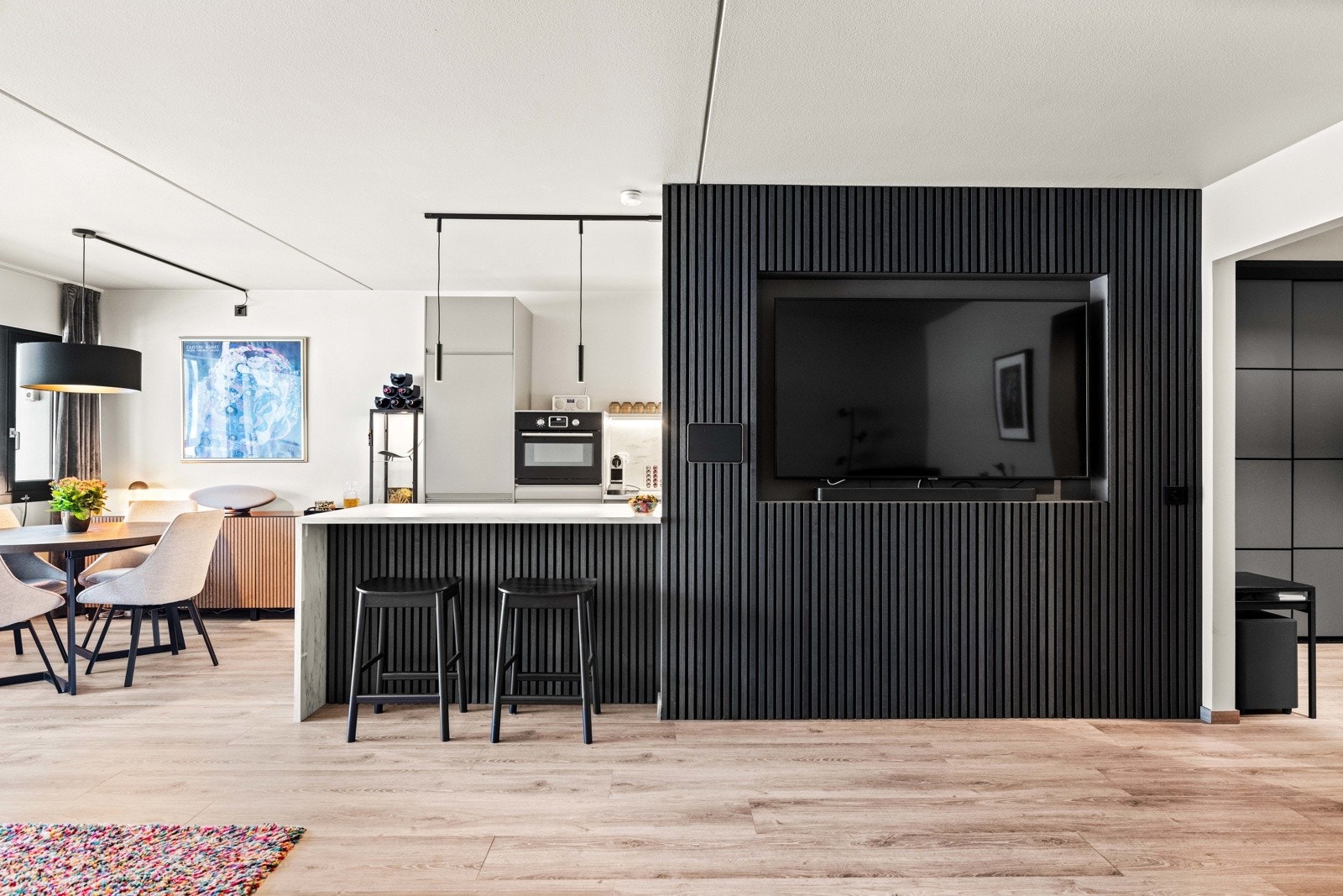 Stor kjøkkenbenk ut mot stuearealet med innfelt sitteplass. Galleribilde