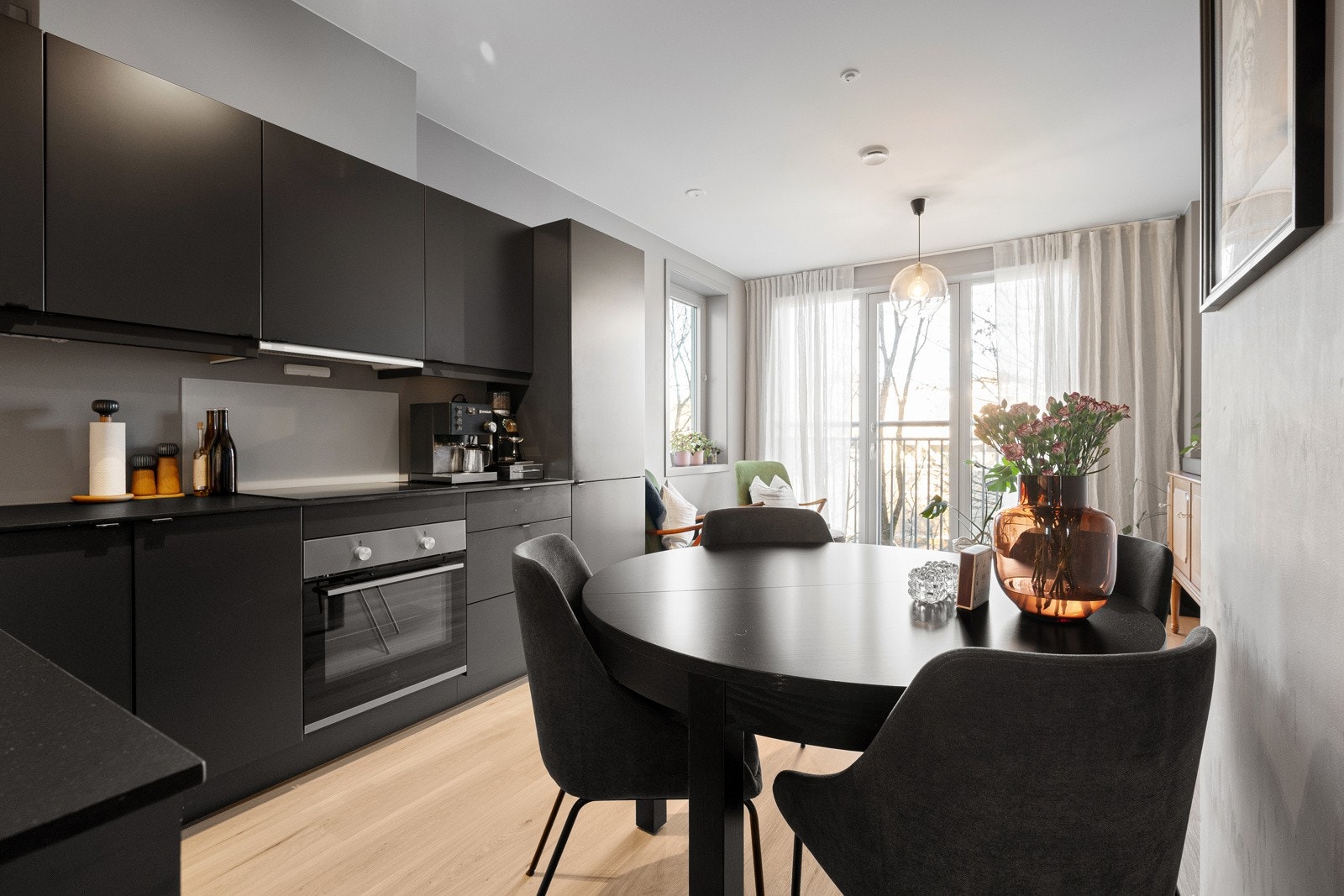 Moderne og funksjonelt kjøkken med mørke, glatte fronter, kompositt benkeplate og integrerte hvitevarer som gir et helhetlig og tidsriktig uttrykk Galleribilde