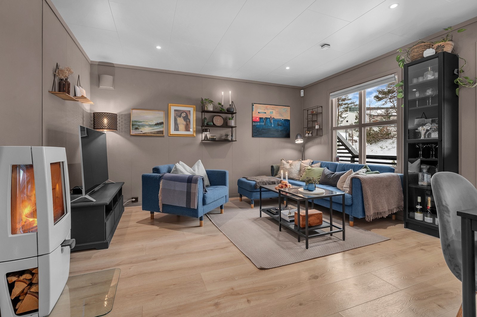 Vedfyrt ovn i stuen som varmer godt om det fyres. Gulvene ble byttet ut i 2020. Galleribilde