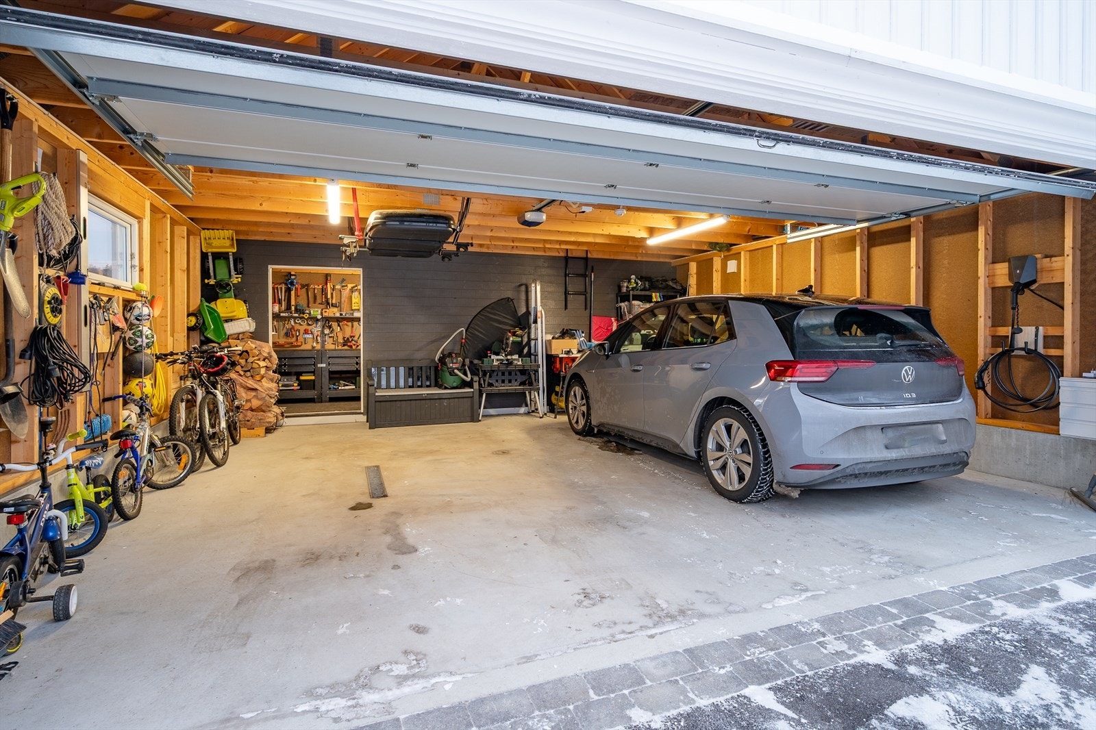 Stor garasje med automatisk port og lagringsmulighet på bjelkelag i himling Galleribilde