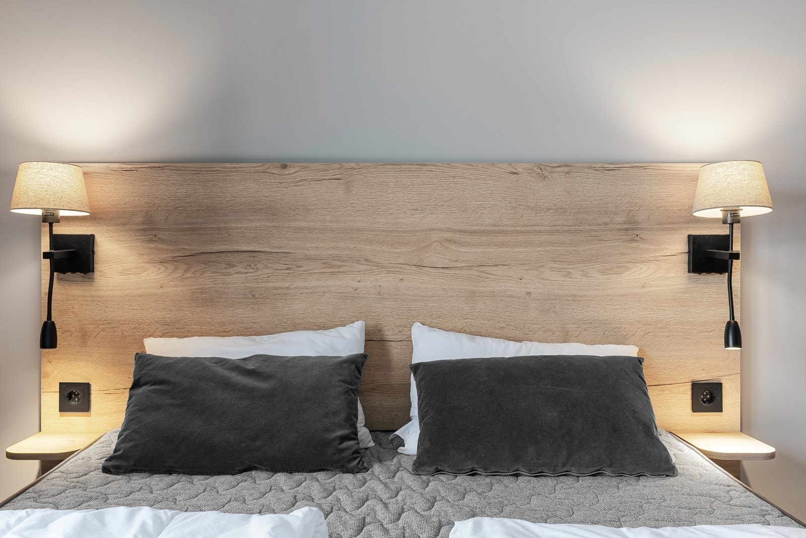 Soverommet har en flott sengegavl med nattbord, stikkontakt og lamper på begge sider. Galleribilde