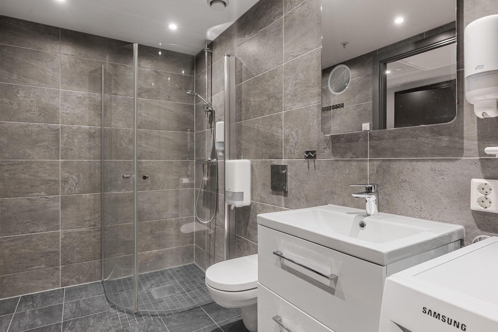 Leiligheten har et stilrent og moderne baderom fra byggeåret 2020. Baderommet har flotte fliser på gulv og vegger, vannbåren gulvvarme, downlights i himlingen og avtrekk via balansert ventilasjon. Galleribilde