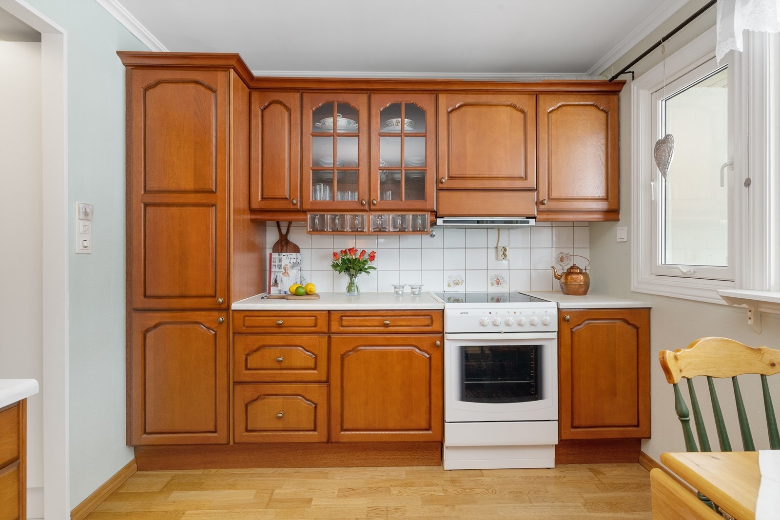 Flis på vegg over benkeplater i laminat, med gode arbeidsflater og nedfelt benkebeslag med dobbel oppvaskkum. Galleribilde