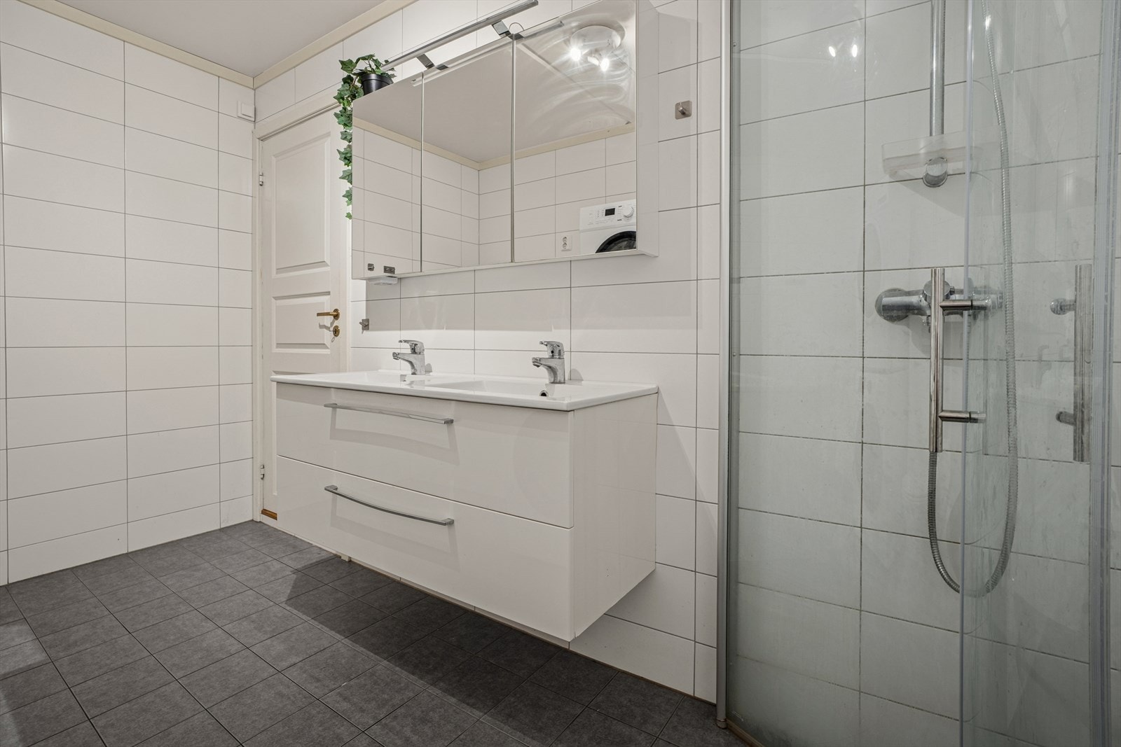 Badet fremstår som et romslig og funksjonelt våtrom med fliser på både gulv og vegger, samt gulvvarme som sørger for ekstra komfort i hverdagen. I følge eier er badet pusset opp i 2017. Galleribilde