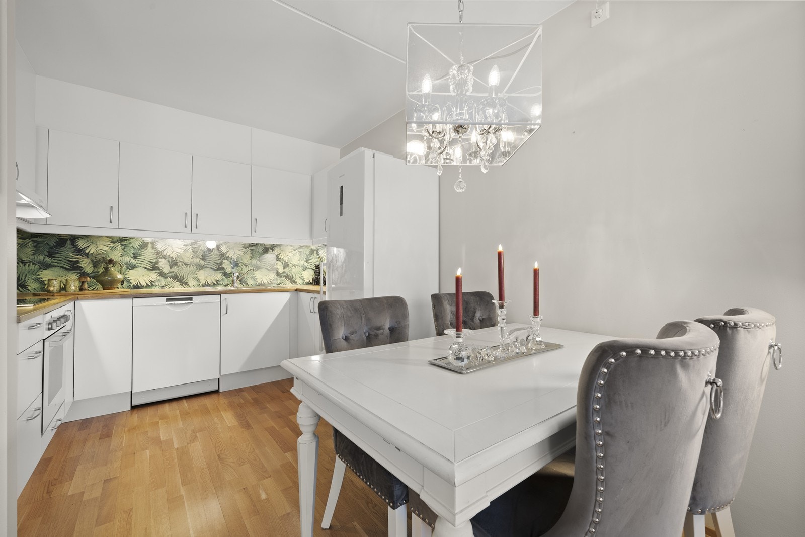 Kjøkkenet har hvite, glatte fronter og benkeplate i tre. Galleribilde