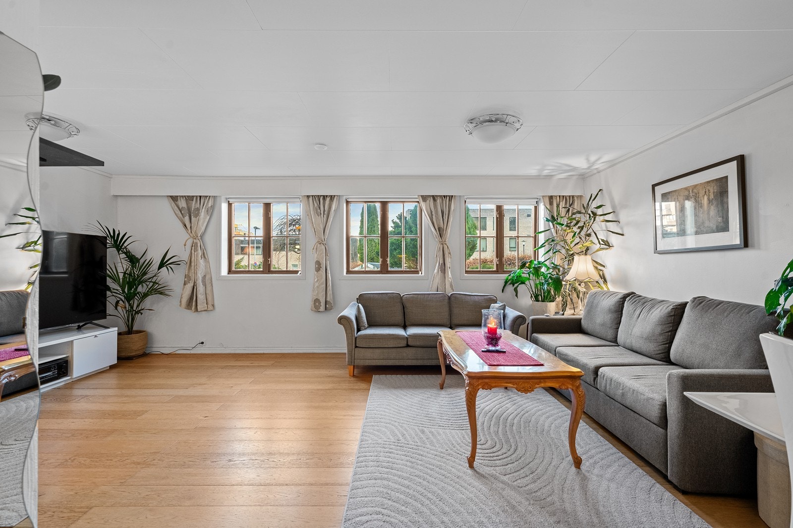 Romslig stue har parkett på gulv og malte flater på vegger. Galleribilde