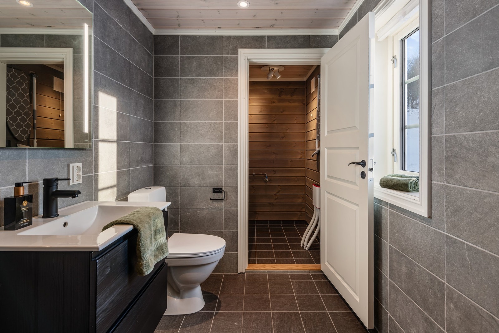 Badet flislagt gulv og vegger, panel i himling Galleribilde