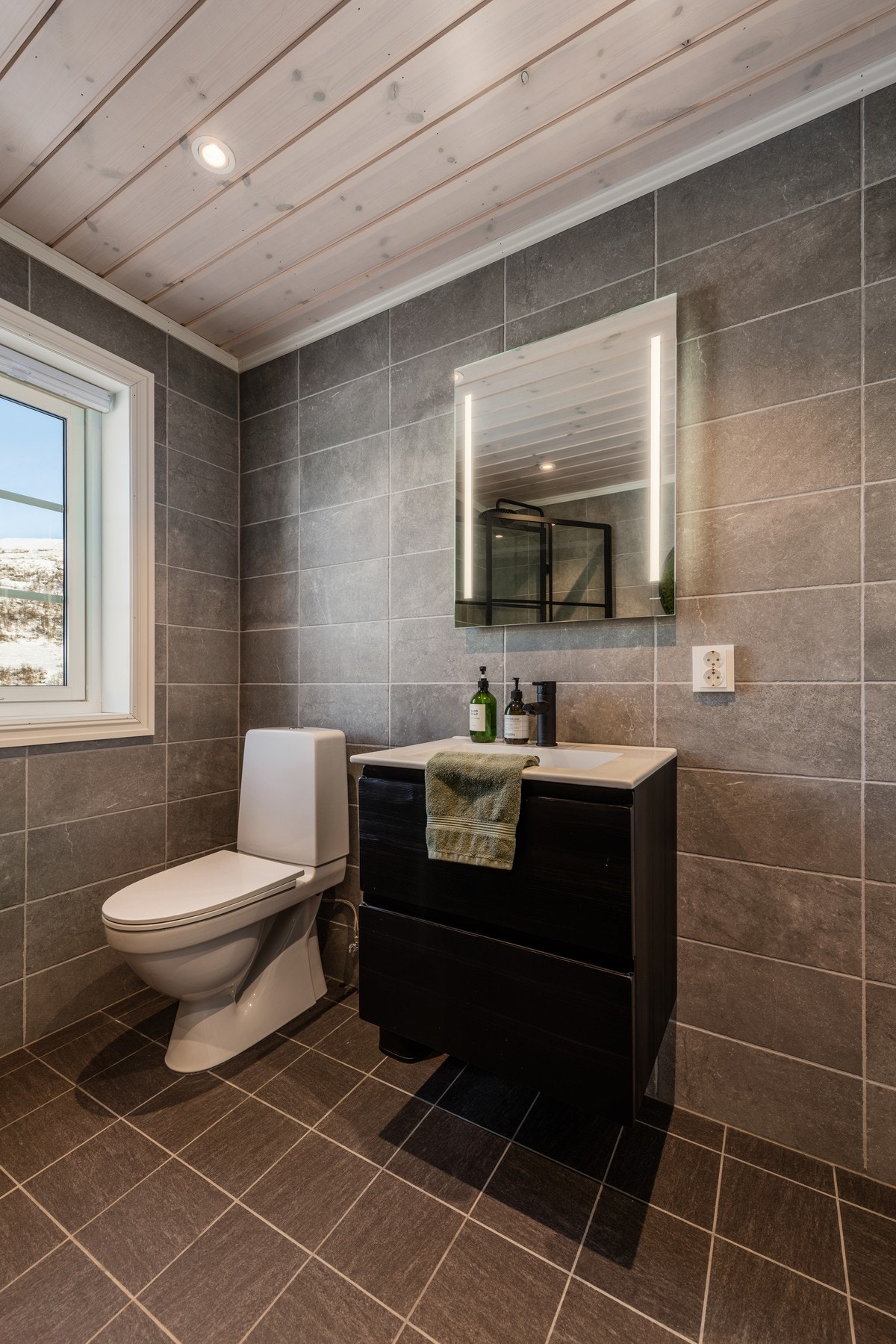 Her har man også fliser på gulv og vegger, og panel i himling Galleribilde