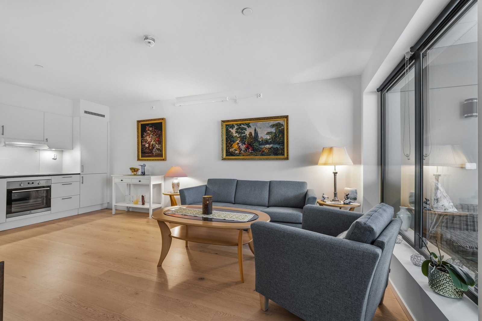 Kjøkkenet har hvite, glatte fronter og laminat benkeplate Galleribilde