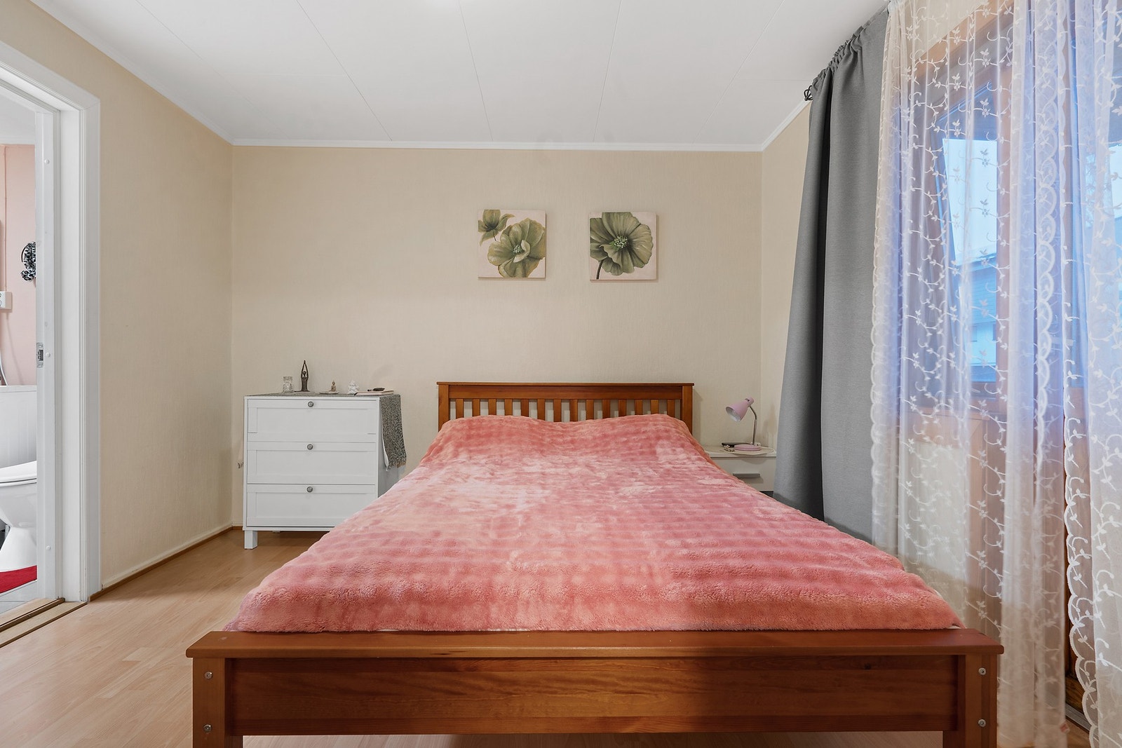 Romslig soverom med malte overflater og laminatgulv. Galleribilde