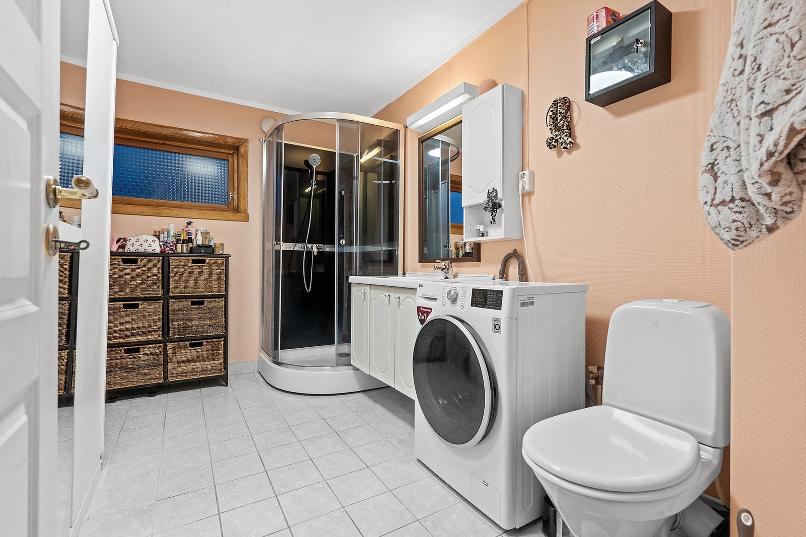 Badet i etasjen har flislagt gulv, dusjkabinett og opplegg for vaskemaskin. Galleribilde