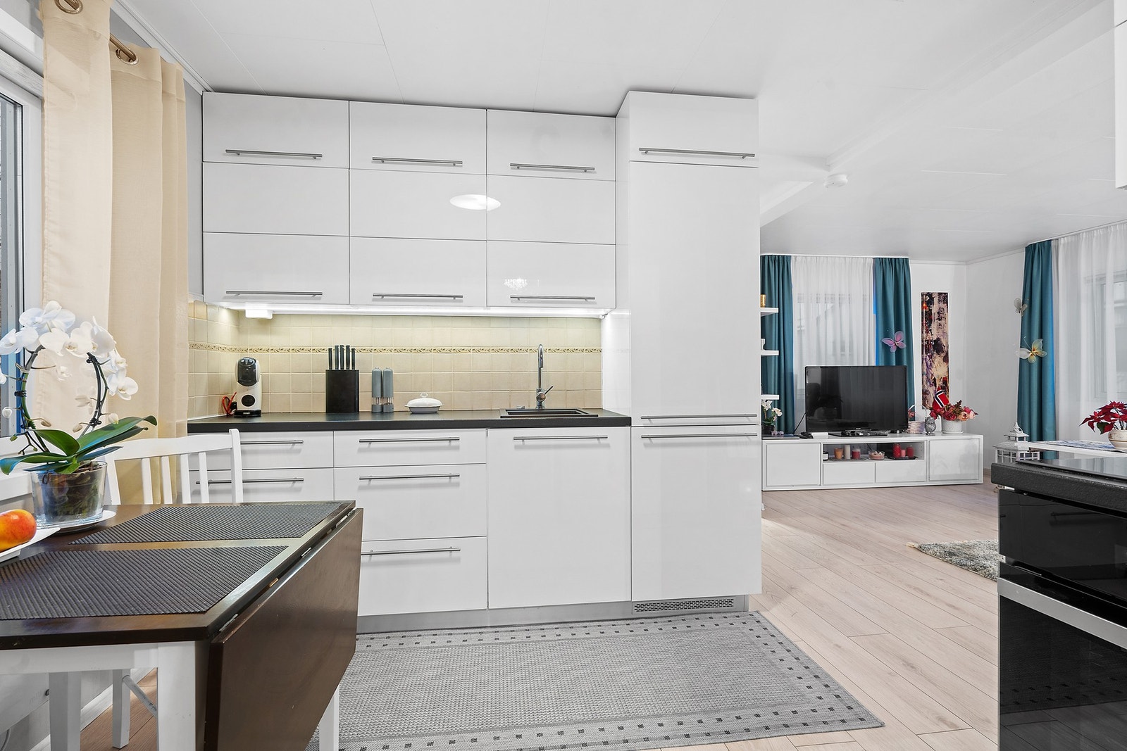 Moderne kjøkken fra 2021 med glatte, hvite fronter og rikelig med skapplass. Galleribilde