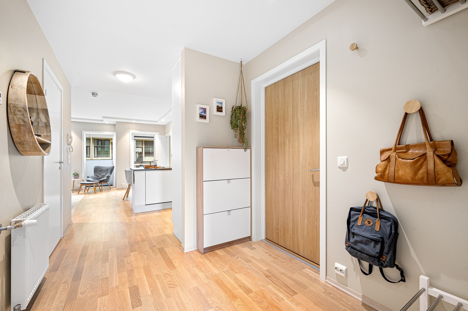 Romslig entrè på ca. 5 kvadratmeter med skoskap og vegghengte knagger for yttertøy. Galleribilde