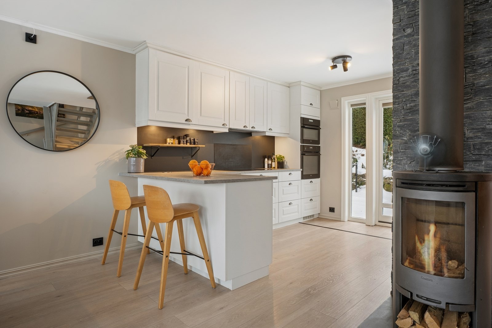 Det moderne kjøkkenet fra 2021 har en profilert innredning fra Kvikk med laminat benkeplate og plater over benken. Galleribilde