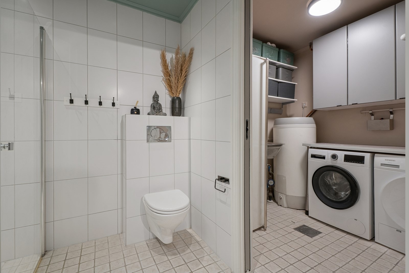 Egen vaskeromsavdeling med praktisk arbeidsflate, god oppbevaringsplass og et gjennomført, ryddig uttrykk. Galleribilde