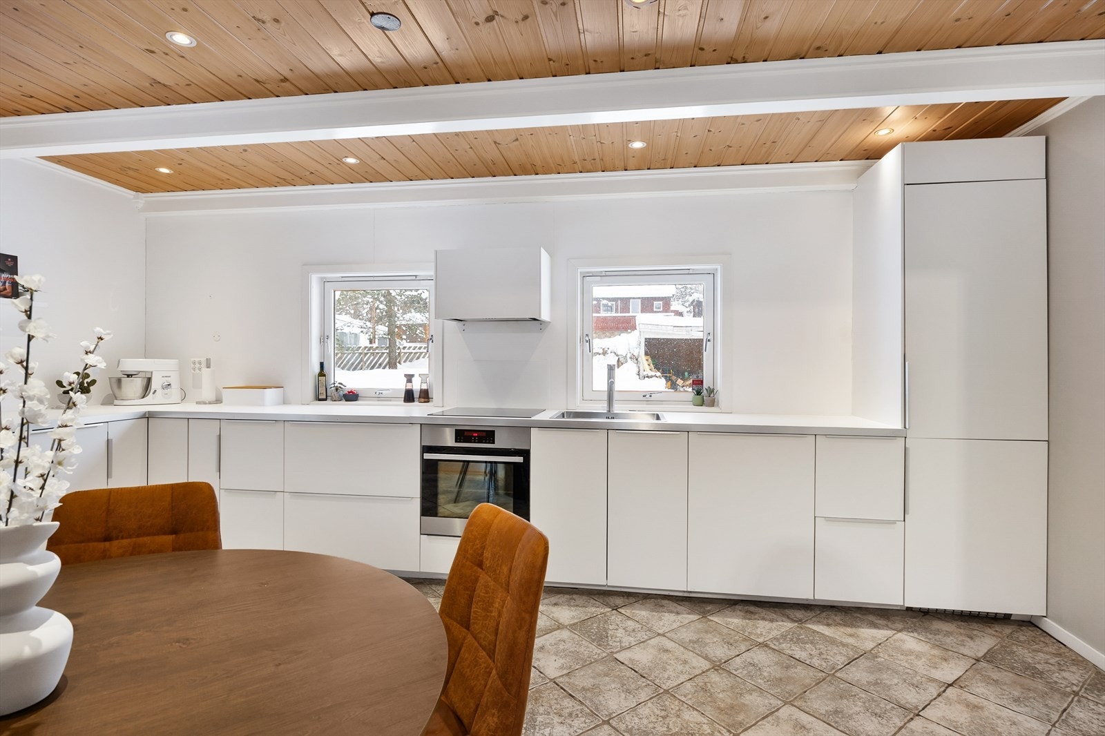 Kjøkkeninnredningen har hvite, glatte fronter og laminert benkeplate. I himling er det montert downlights. Galleribilde