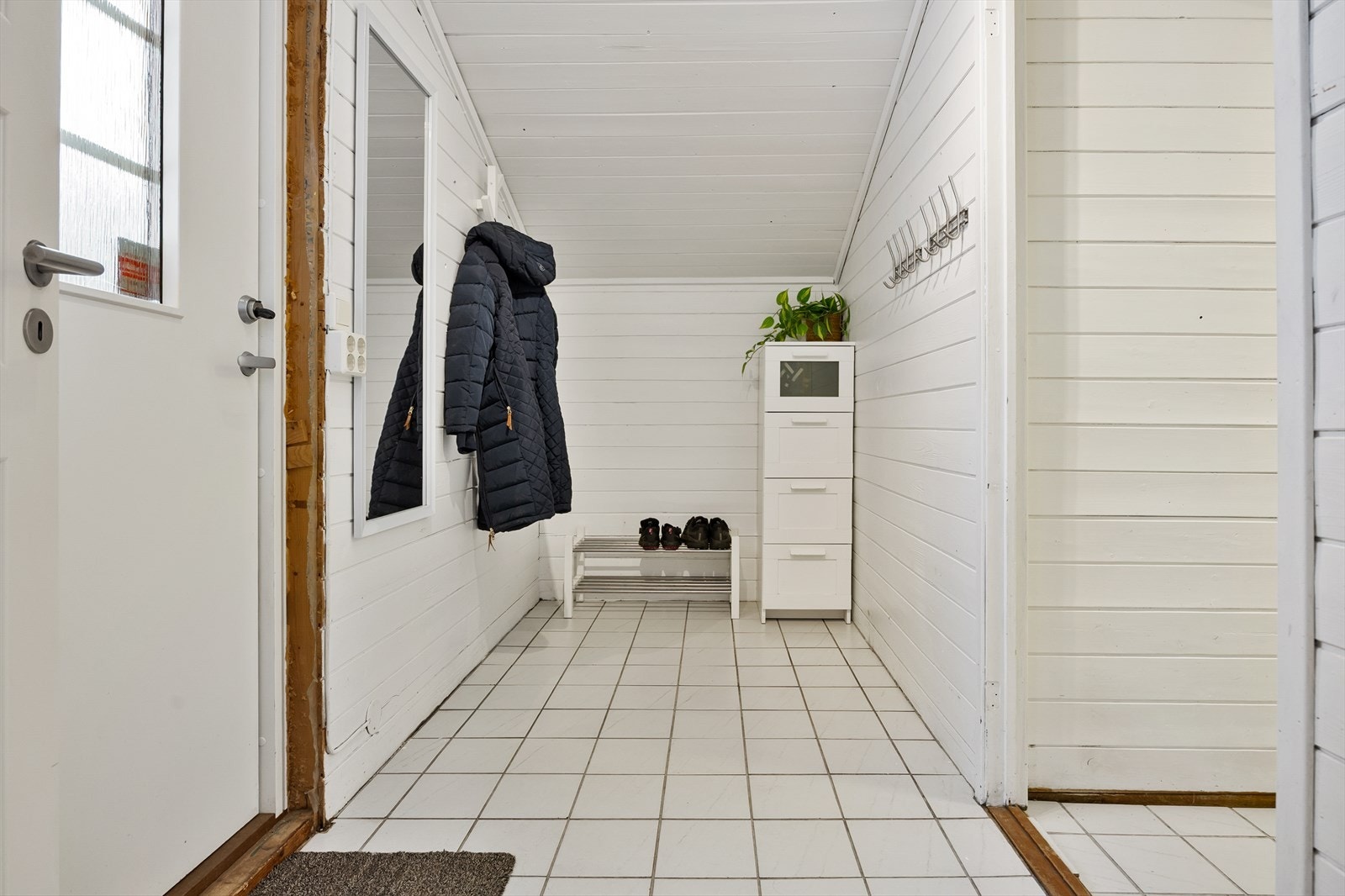 Ekstra inngang til boligen med adkomst til gang, vaskerom og bod. Galleribilde