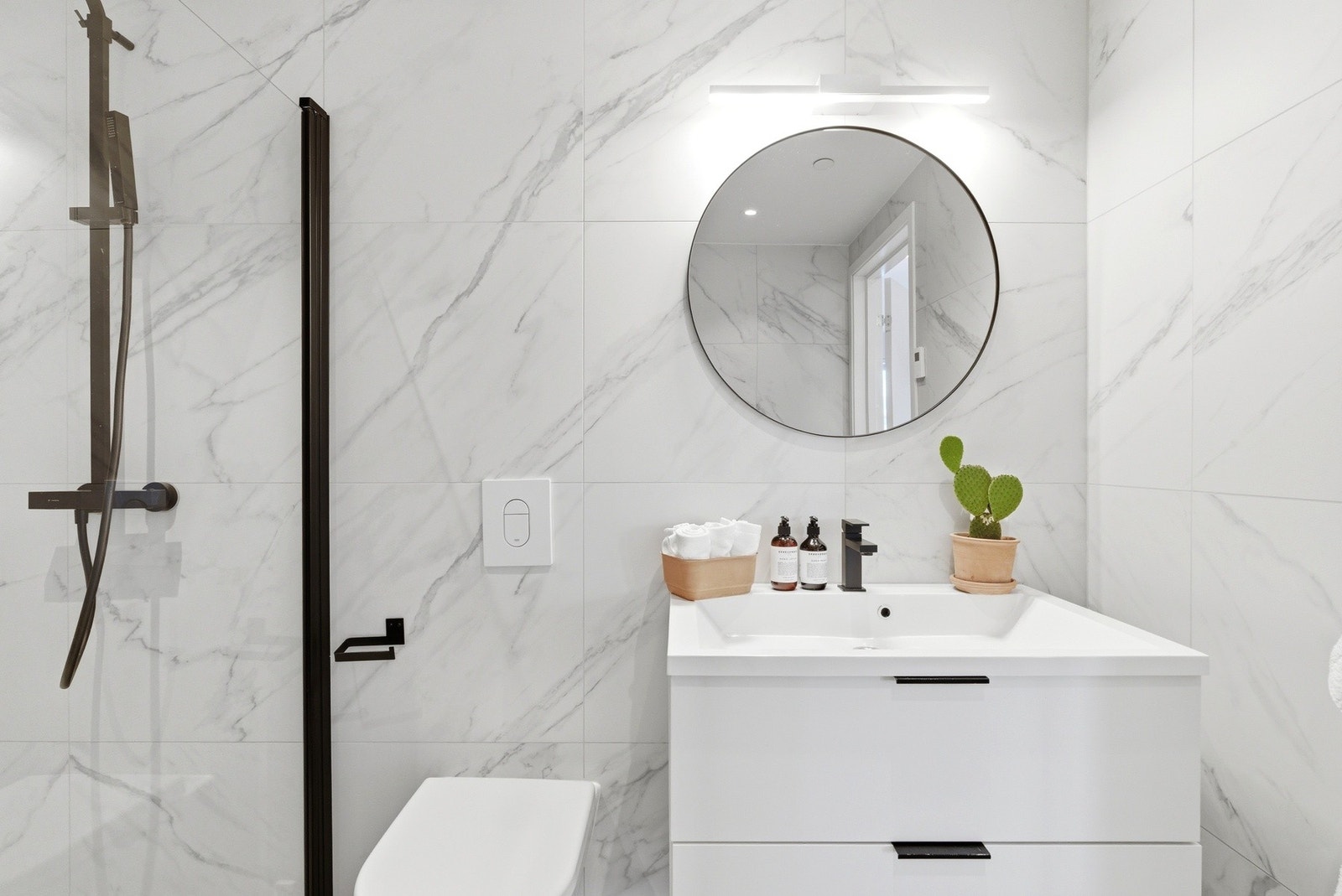 Et gjennomført og svært brukervennlig baderom med god plass til ekstra oppbevaringsmøbler om ønskelig. Galleribilde