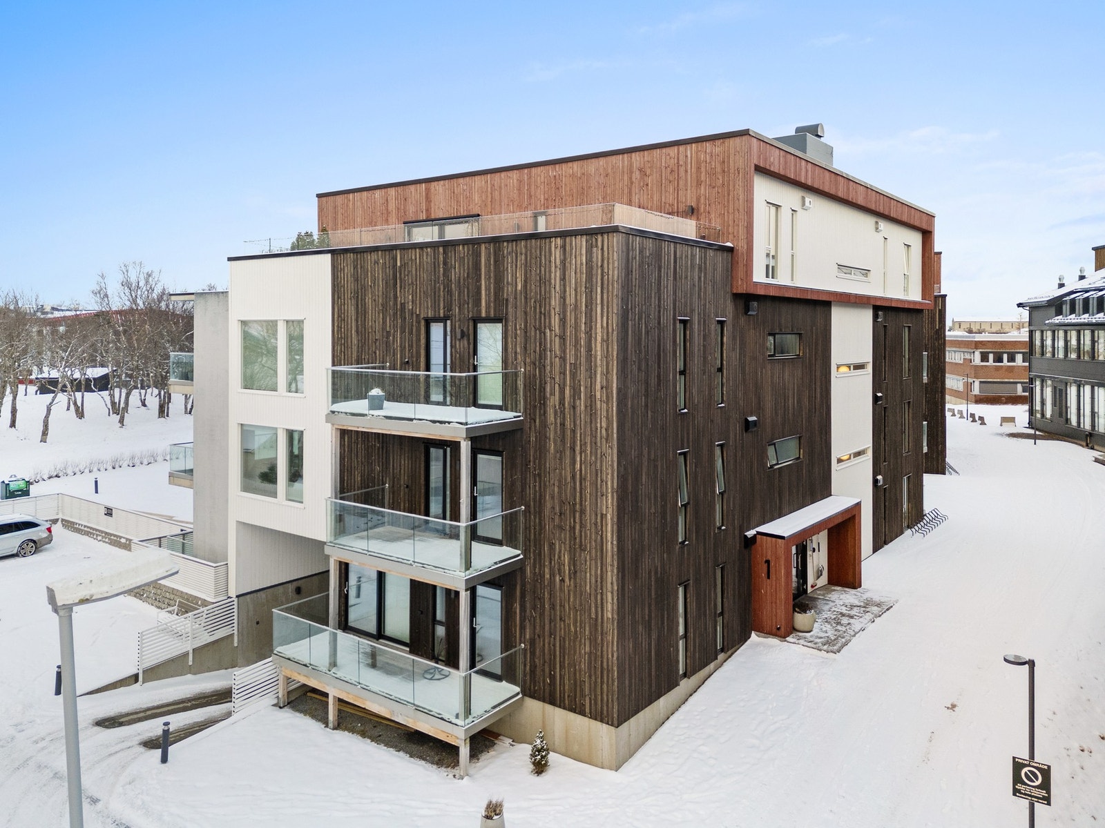 Innkjøring til garasje på sørsiden av blokka, og inngang til bygget på østsiden. Galleribilde