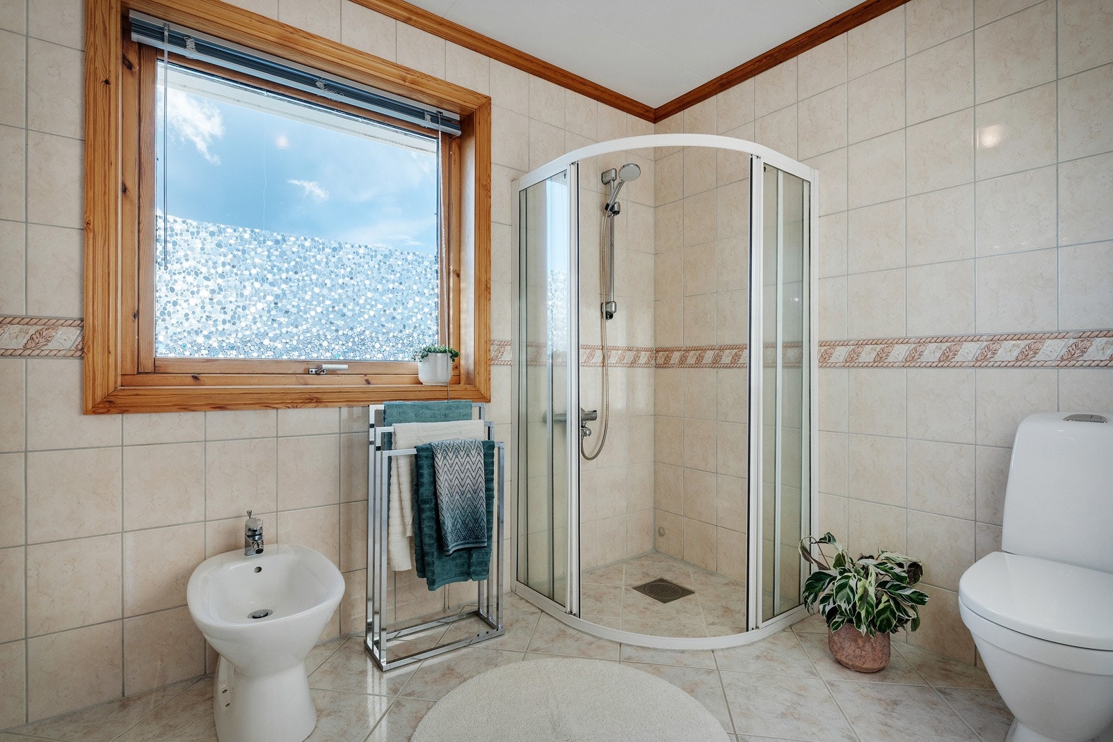 Badet er utstyrt med dusj, toalett og baderomsinnredning med heldekkende servant samt belyst speil. Galleribilde