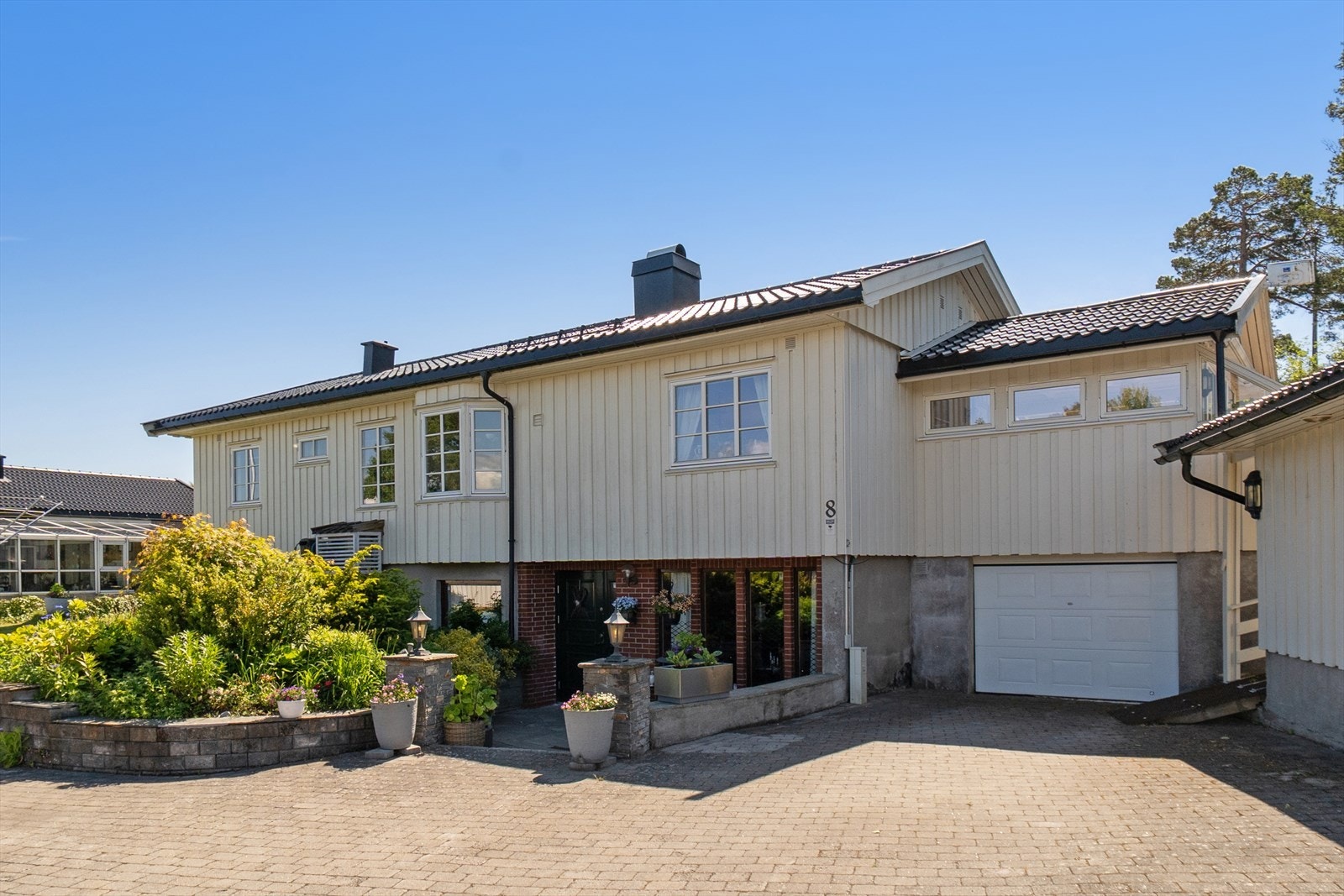 Eiendommen er velstelt og pent beplantet rundt hele boligen. Gårdsplassen er opparbeidet med belegningsstein. Galleribilde