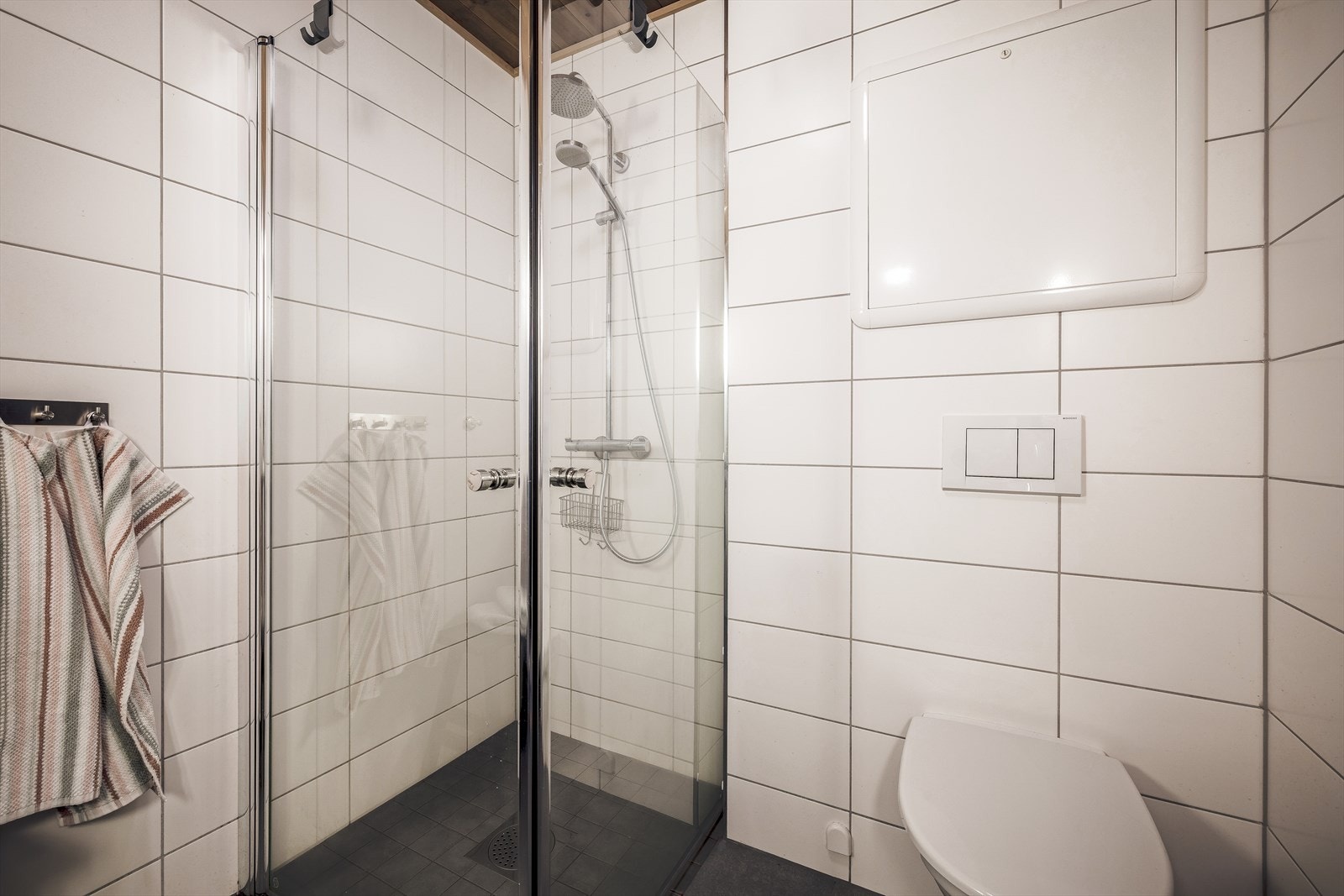 Badet er innredet med dusjhjørne, toalett og servant med skap, og har varmekabler i gulv Galleribilde