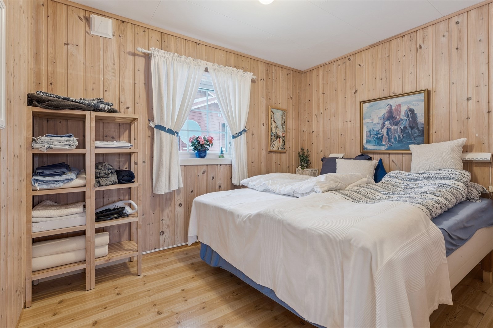 Romslig hovedsoverom med trepanel på veggene og plass til dobbeltseng. Galleribilde