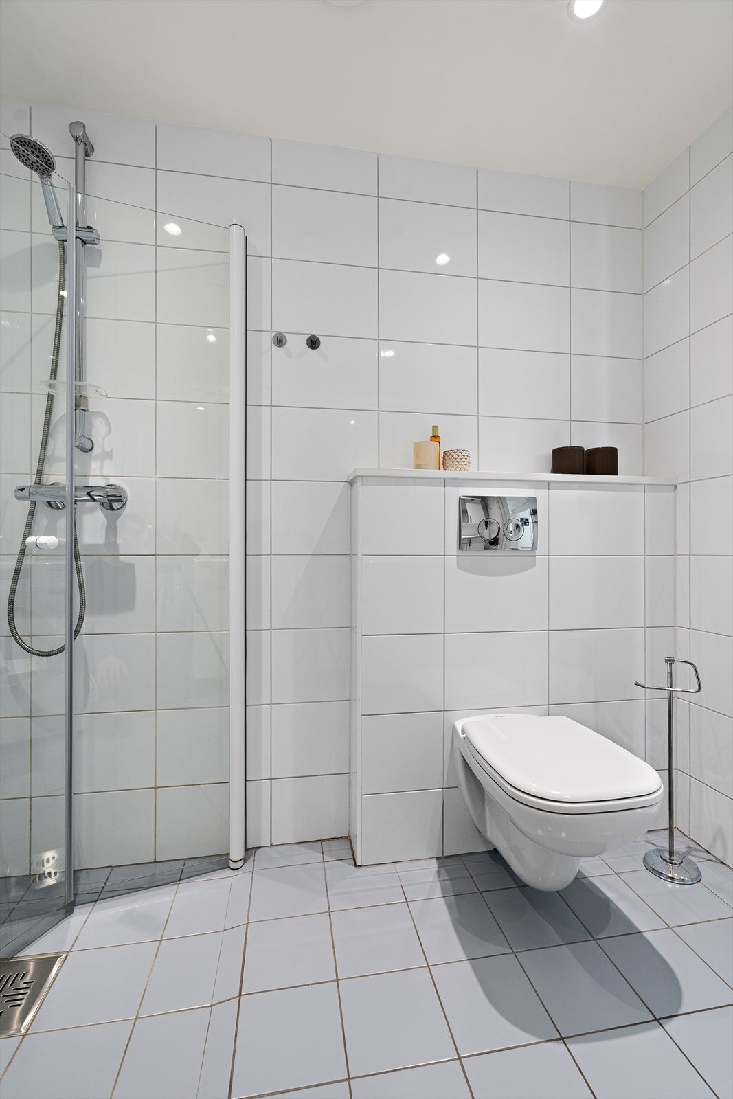 Baderomsinnredningen består av dusj med glassdører og toalett. Galleribilde