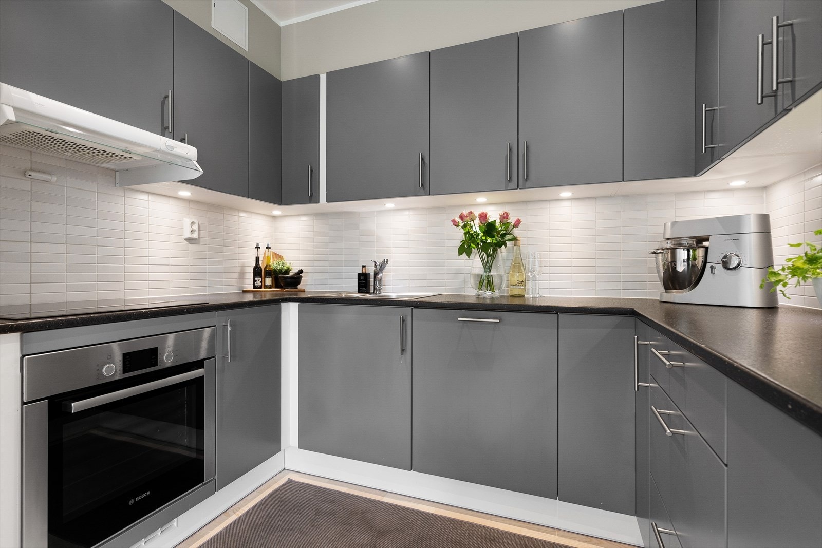 Kjøkkenet har innredning med grå, glatte fronter og benkeplaten er av laminat. Galleribilde