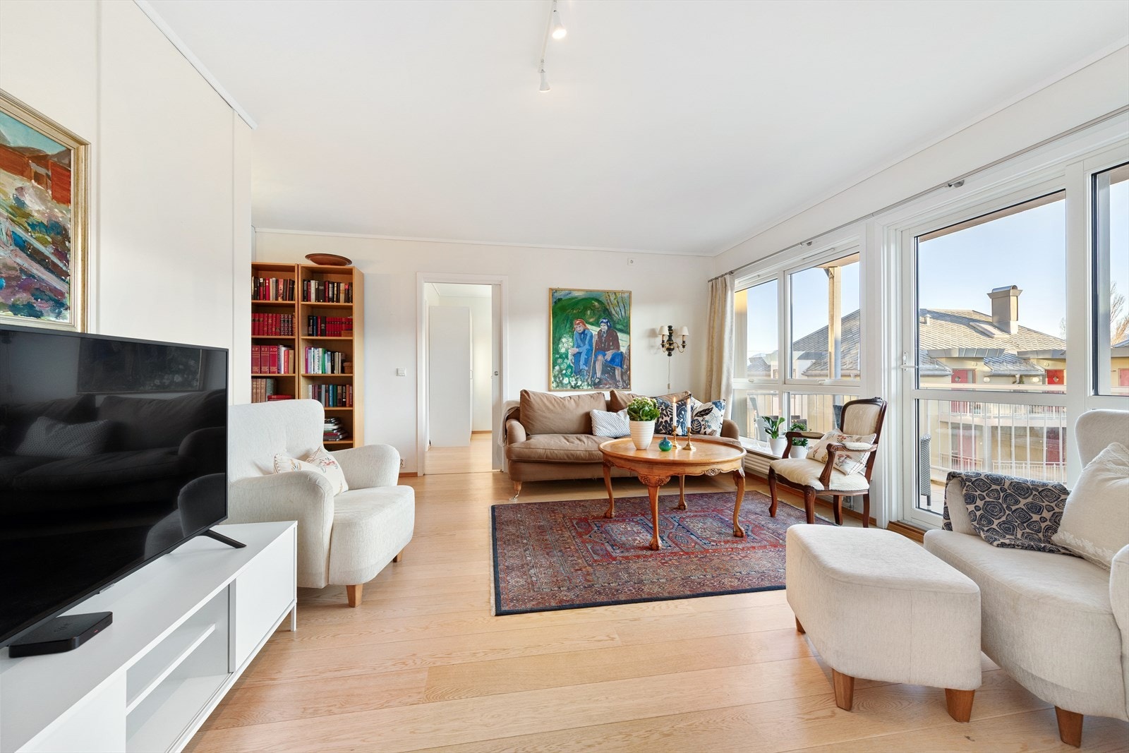 Lys stue med parkett på gulv. Det er også pipe i leiligheten med mulighet til å knytte seg til ildsted Galleribilde