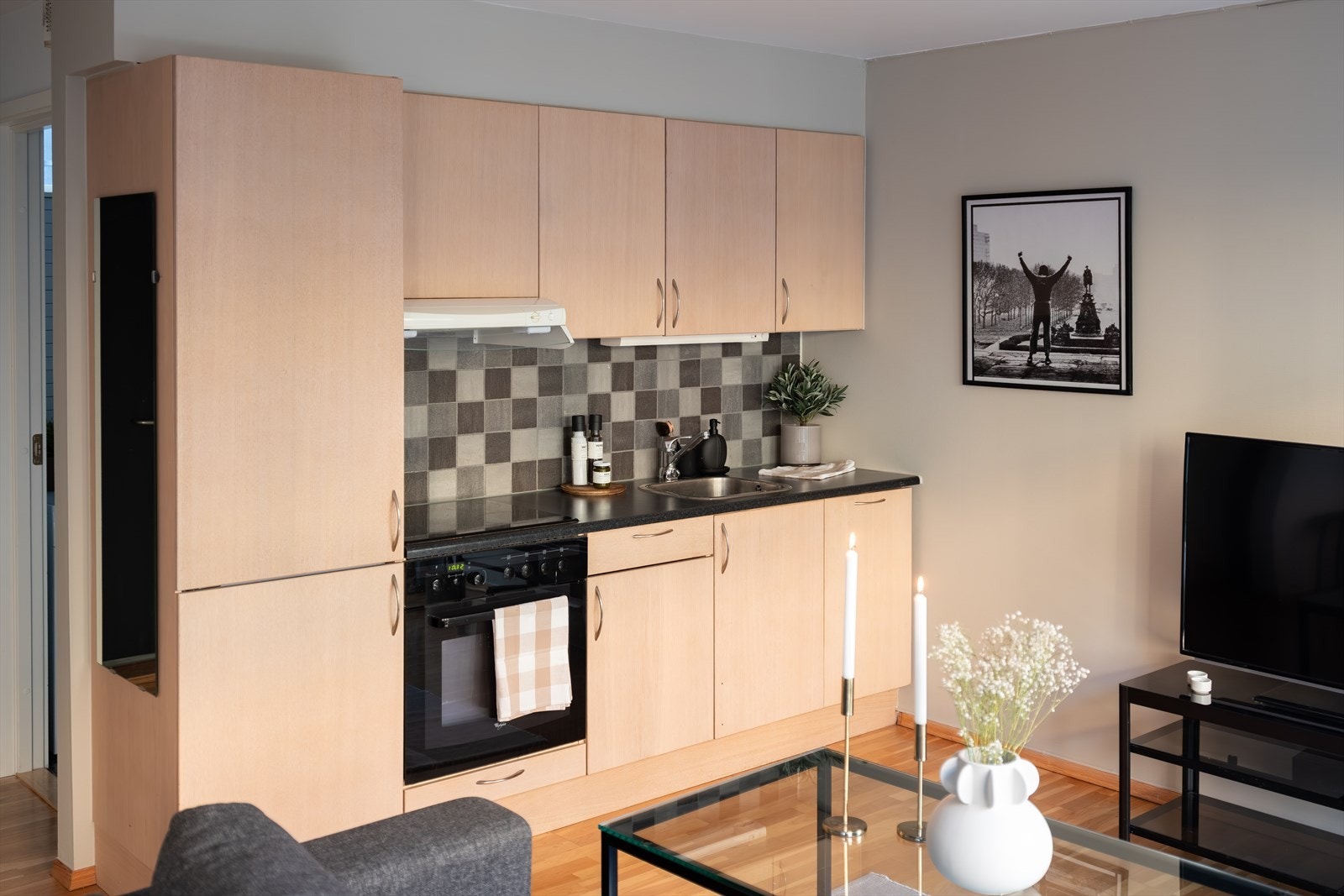 Tidløst kjøkken med integrerte hvitevarer som platetopp, stekeovn, oppvaskmaskin, kjøl- og fryseskap som medfølger handelen. Galleribilde