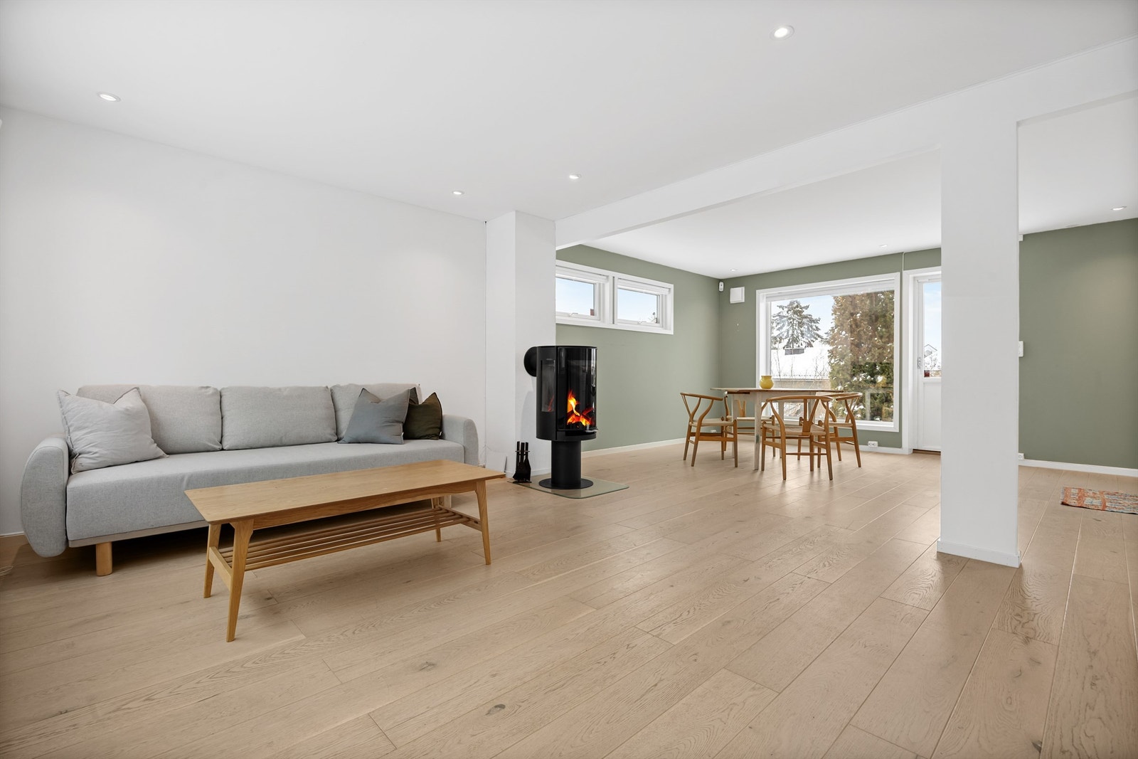 Åpen kjøkken- og stueløsning med sofaområde samt spiseplass Galleribilde