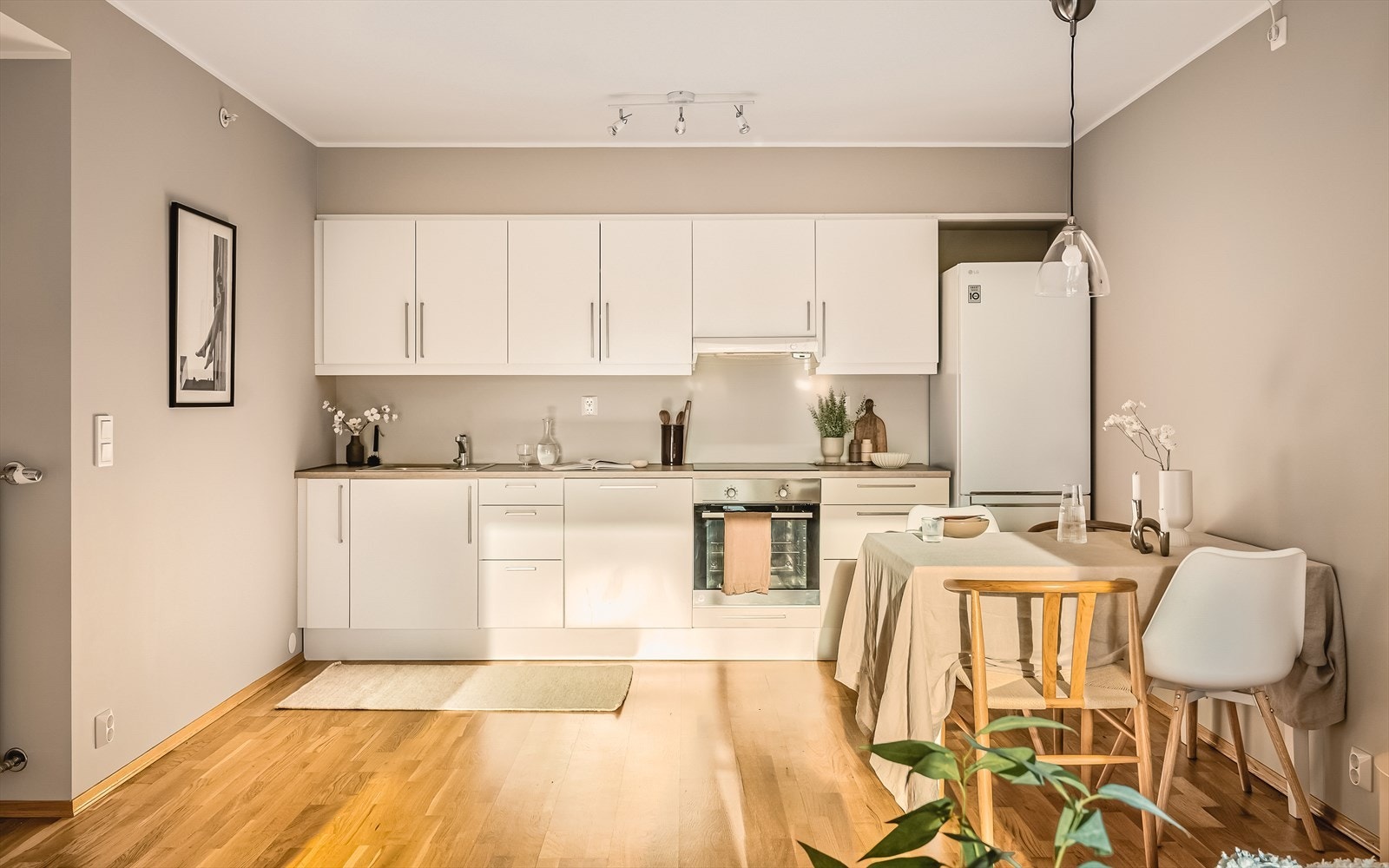 Kjøkkeninnredningen er levert av Sigdal, med slette hvite fronter som gir et rent og stilfullt preg. Kjøkkenet er utstyrt med laminat benkeplate, stål vaskekum og ventilator. Galleribilde