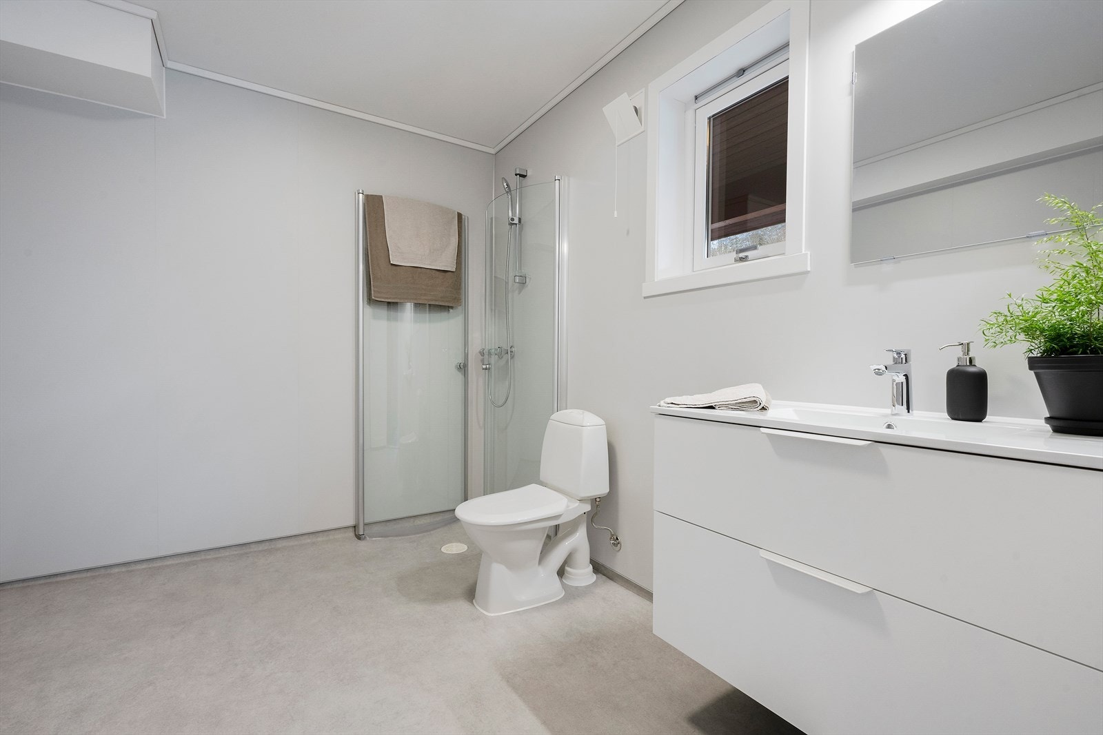 Badet er innreidd med klosett, servant i underskap og dushjørne med svingdører Galleribilde