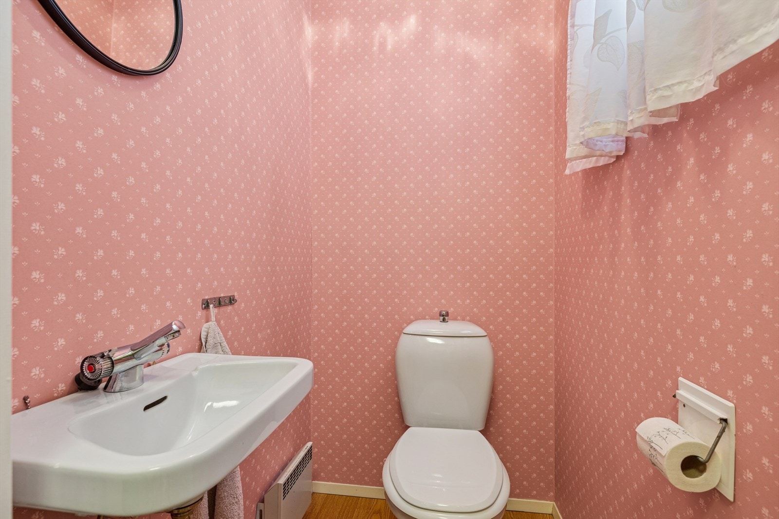 Toalettrom med laminat på gulv og tapet på vegger. Rommet har toalett og servant. Naturlig ventilert. Galleribilde