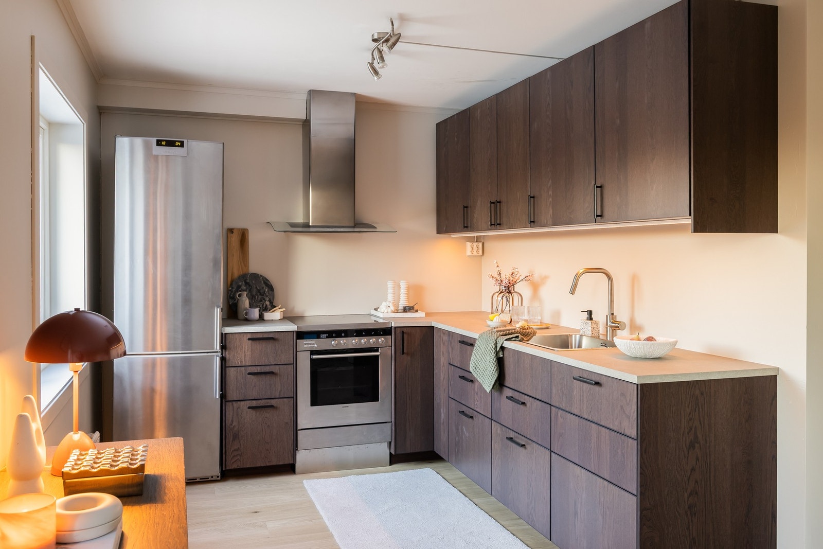 Stilren kjøkkeninnredning med glatte fronter og laminat benkeplate, og rikelig med oppbevaring. Galleribilde