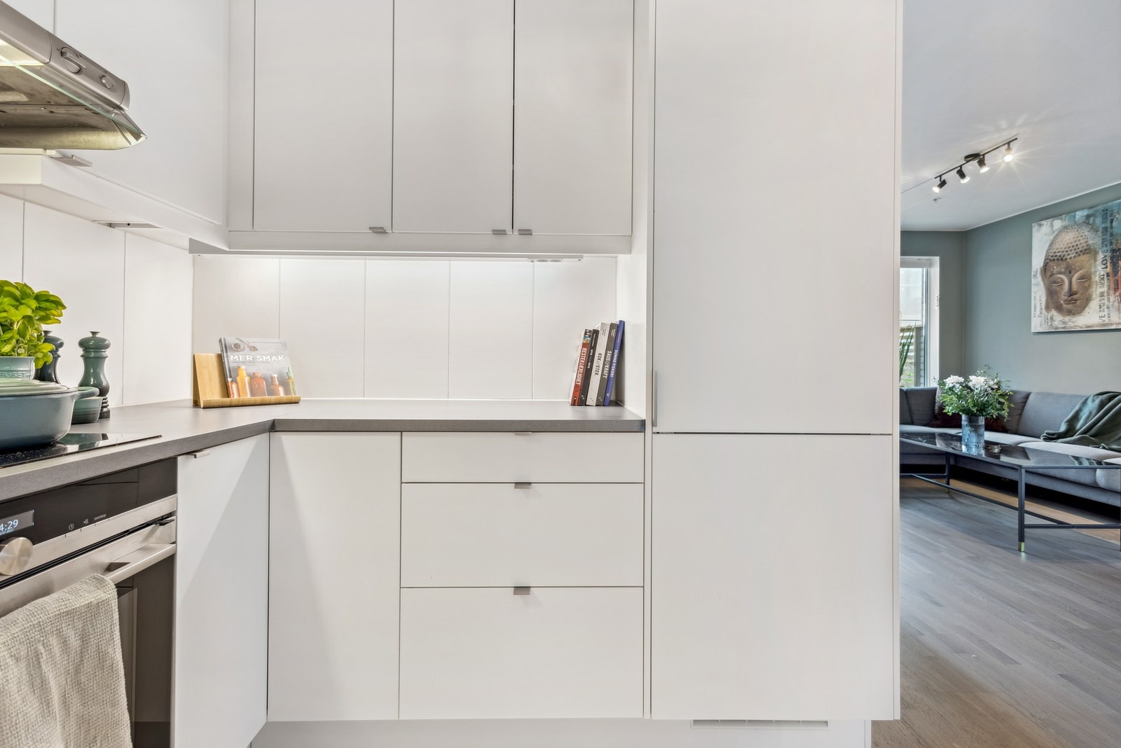 Kjøkkenet er lyst og innbydende, med god skap og benkeplass, glatte folierte fronter og en pen benkeplate. Galleribilde